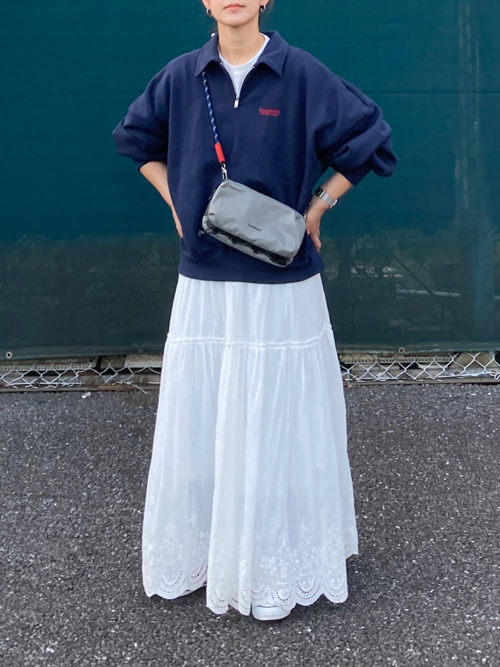 ブルー系のスウェット、ホワイト系のスカート、グレー系のショルダーバッグを着用したレディースの秋コーディネートの3枚目の写真