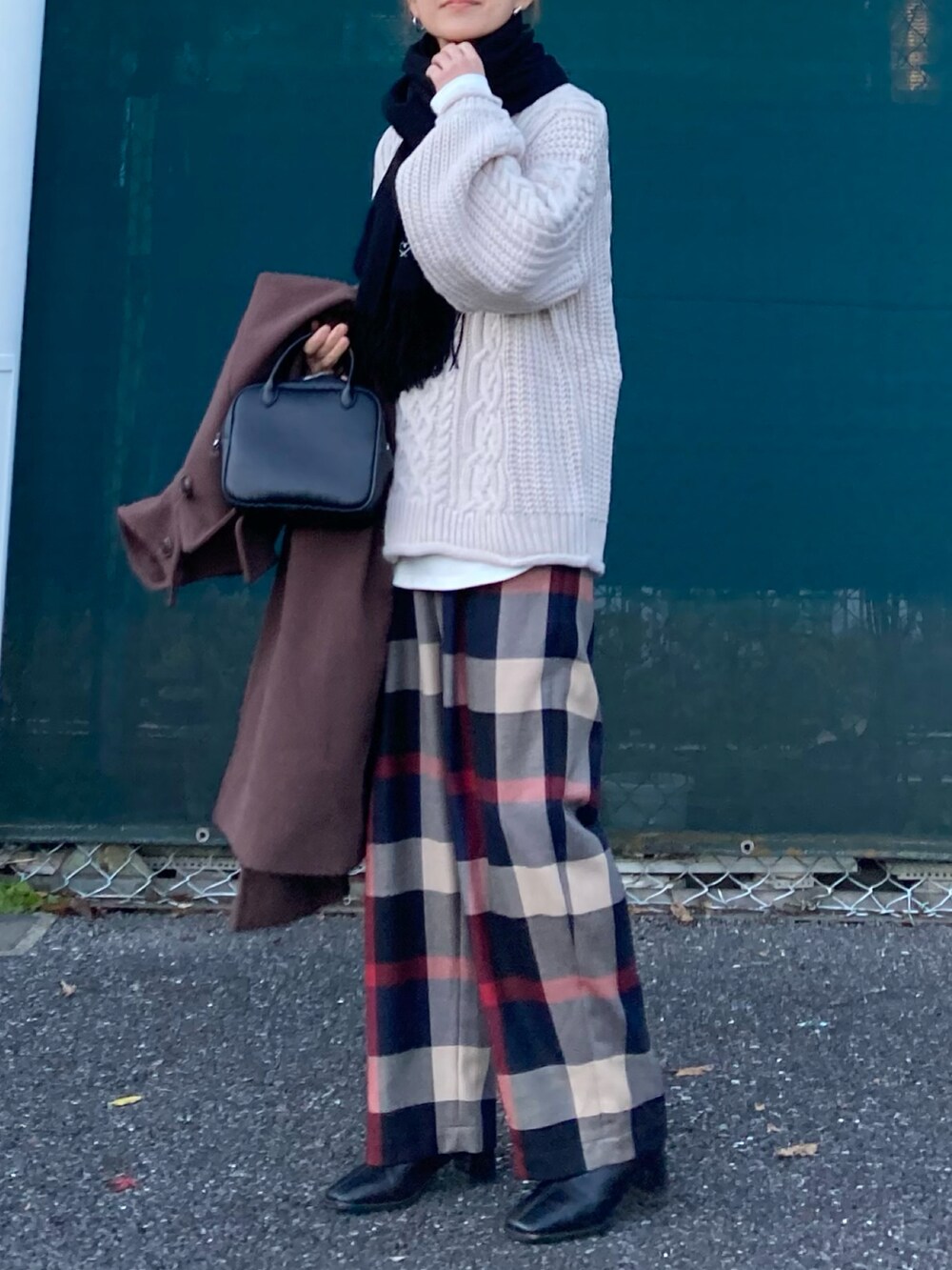 ベージュ系のニット/セーター、ブルー系のその他パンツ、ブラック系のボストンバッグを着用したレディースの冬コーディネートの4枚目の写真