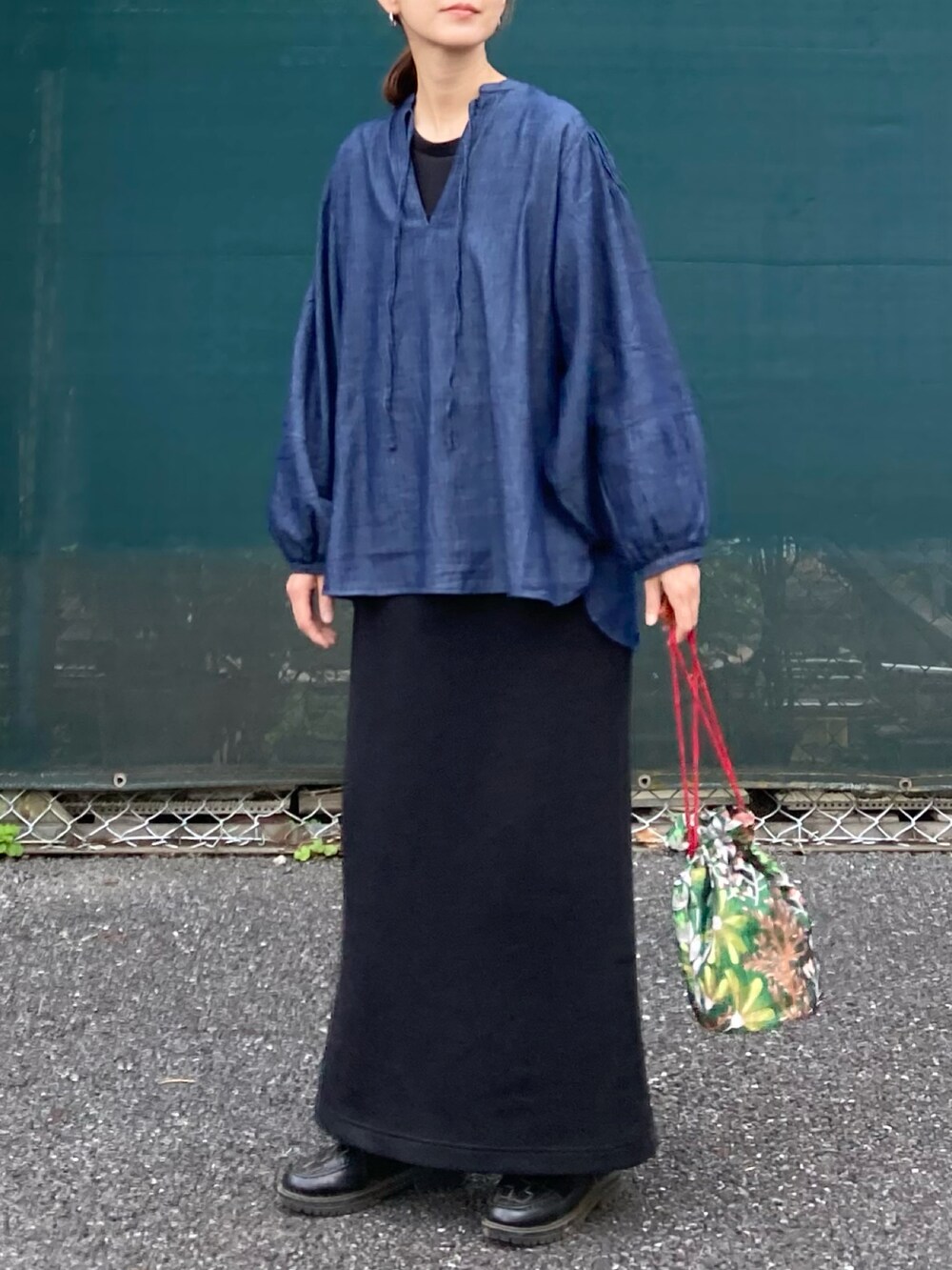 ブラック系のワンピース、ブルー系のシャツ/ブラウス、グリーン系のショルダーバッグを着用したレディースの春コーディネートの2枚目の写真