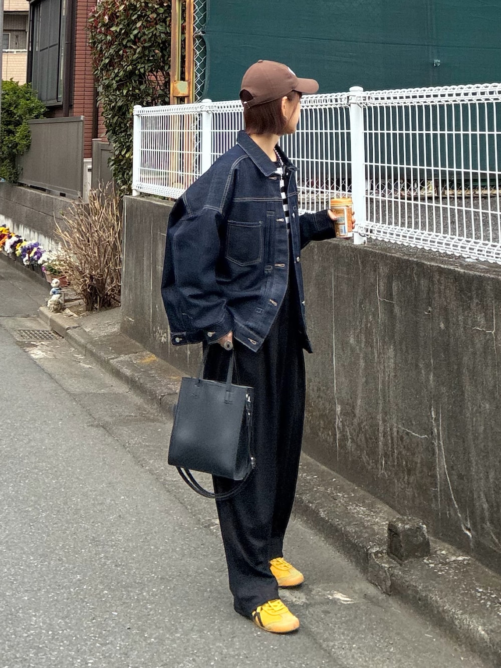 ブラック系のTシャツ/カットソー、ブルー系のデニムジャケット、ブラック系のスラックスを着用したレディースの春コーディネートの2枚目の写真