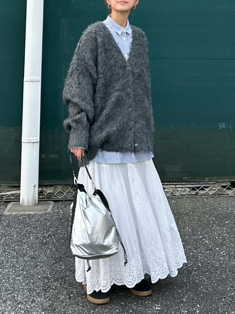 グレー系のカーディガン/ボレロ、ブルー系のシャツ/ブラウス、シルバー系のショルダーバッグを着用したレディースの秋コーディネートの2枚目の写真