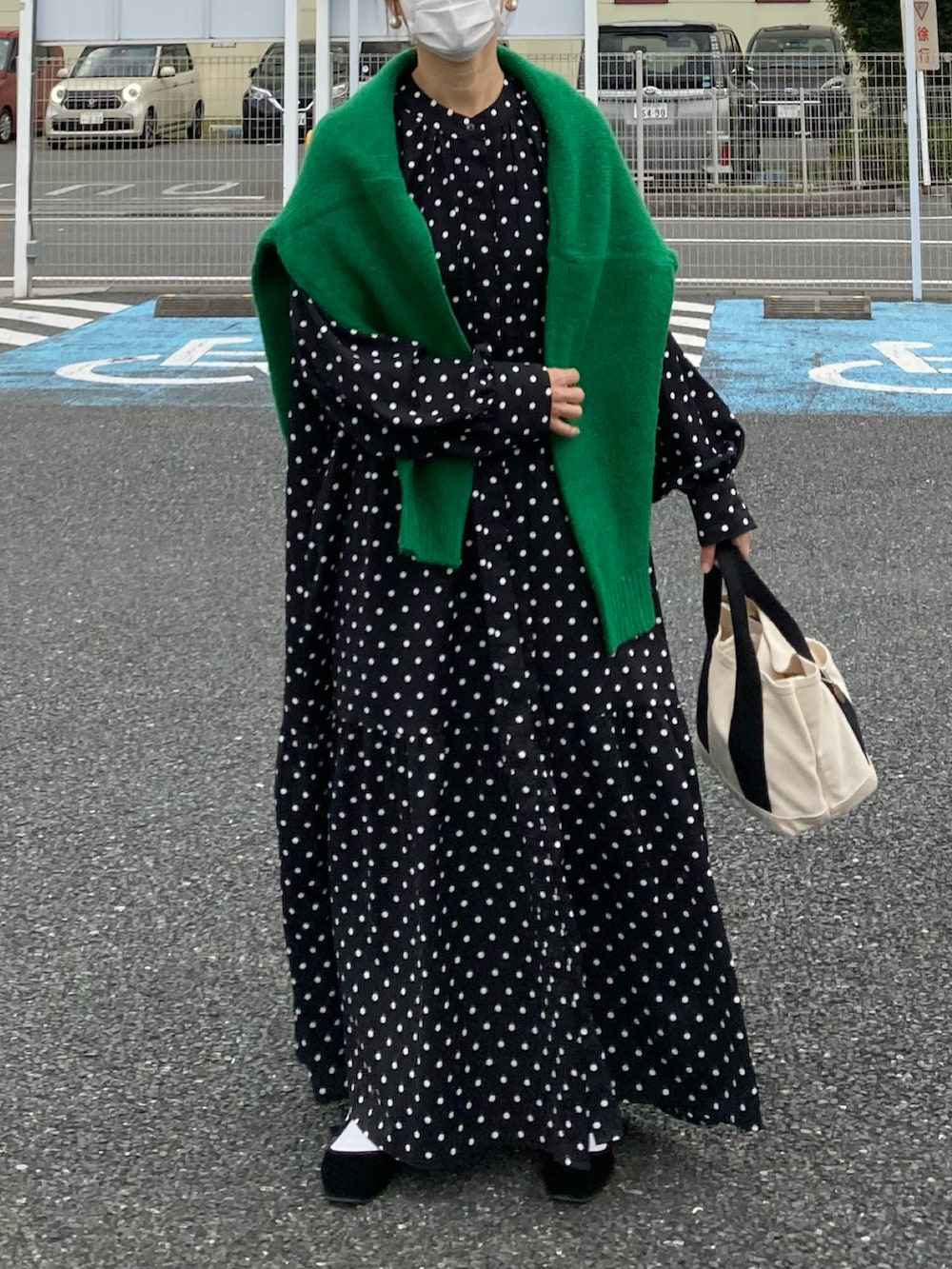 ブラック系のシャツワンピース、グリーン系のニット/セーター、ホワイト系のトートバッグを着用したレディースの秋コーディネートの2枚目の写真