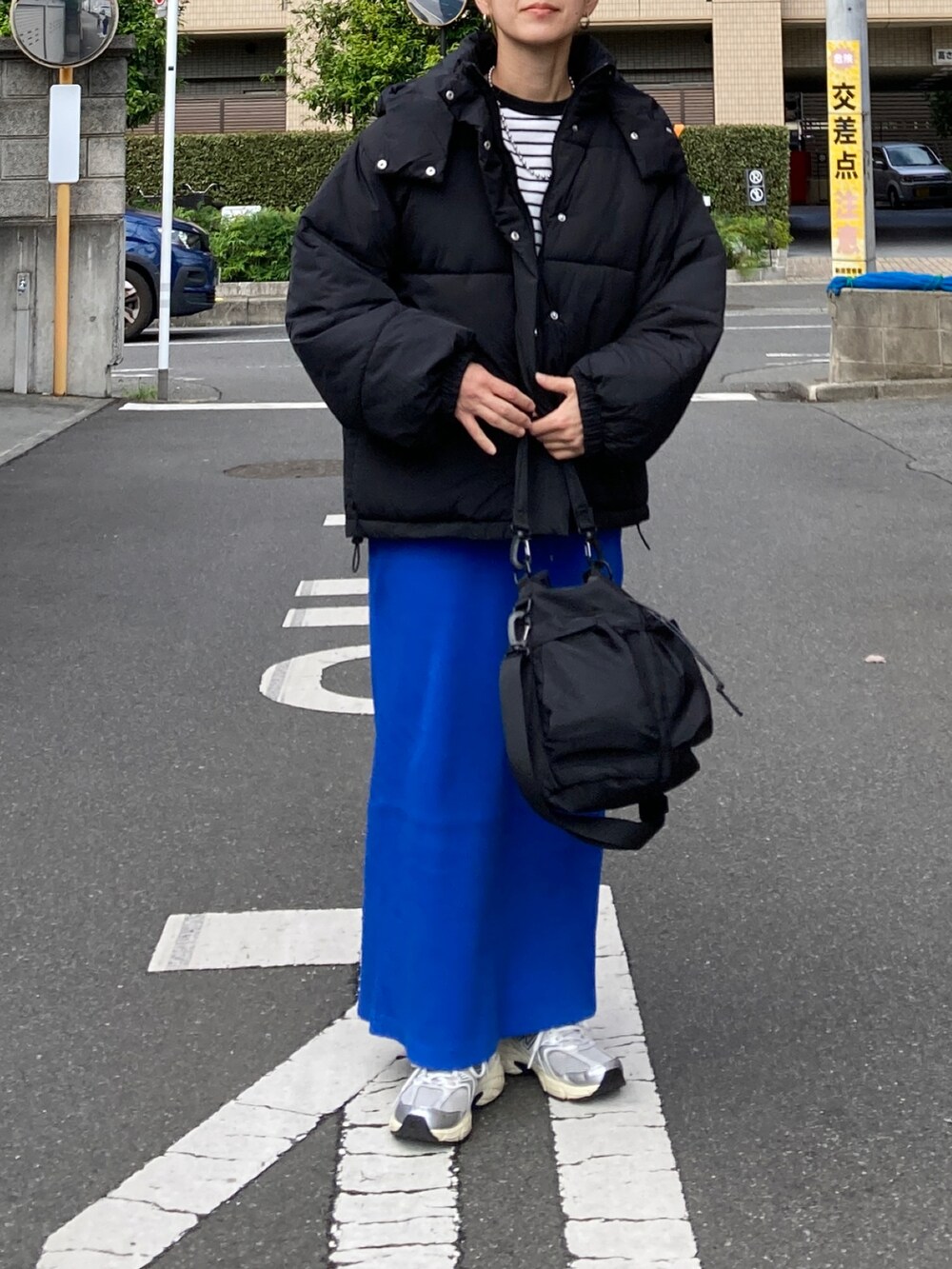 ブラック系のダウンジャケット/コート、ブラック系のTシャツ/カットソー、ブルー系のスカートを着用したレディースの秋コーディネートの3枚目の写真