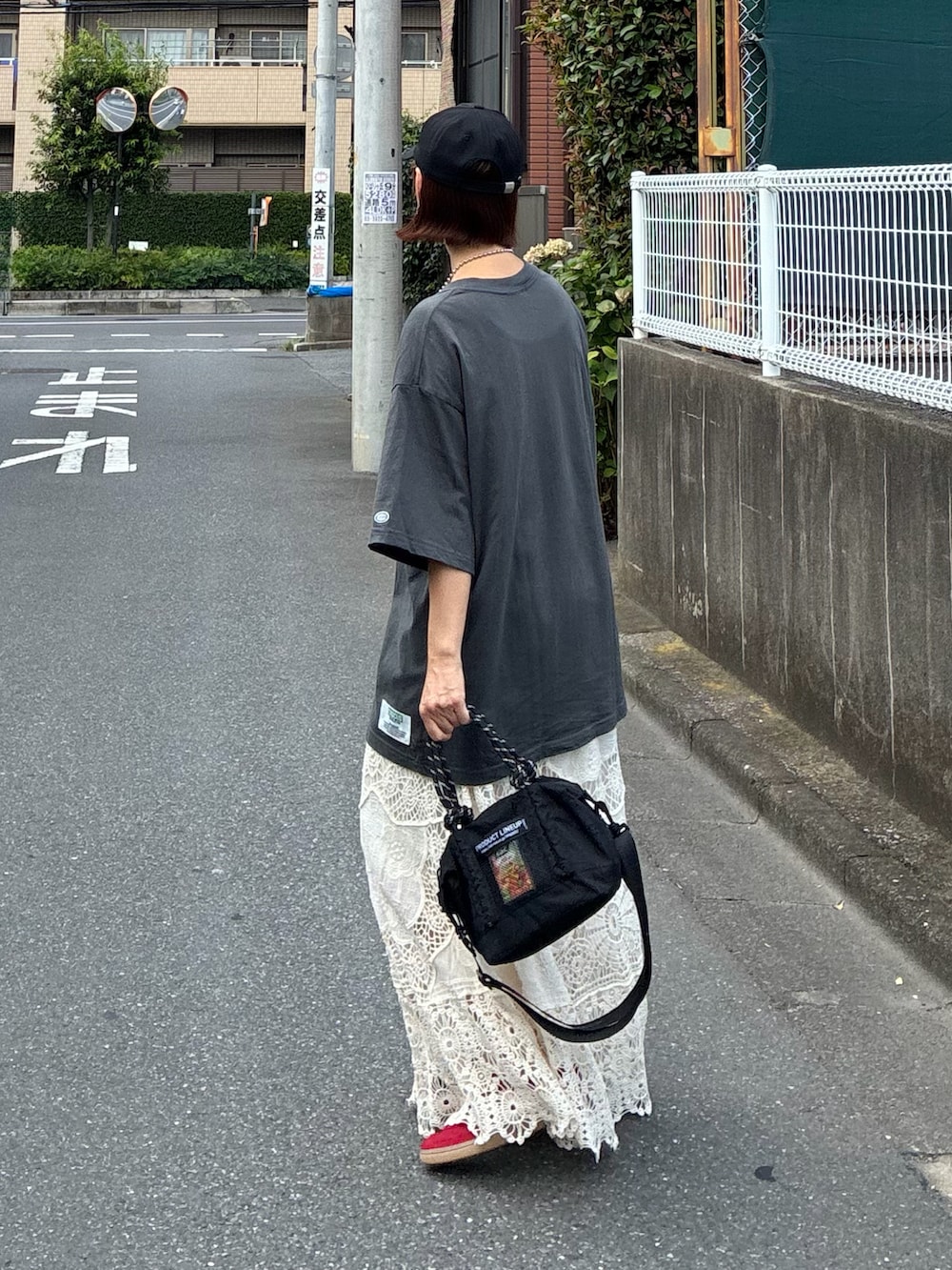 グレー系のTシャツ/カットソー、ホワイト系のスカート、ブラック系のトートバッグを着用したレディースの夏コーディネートの5枚目の写真