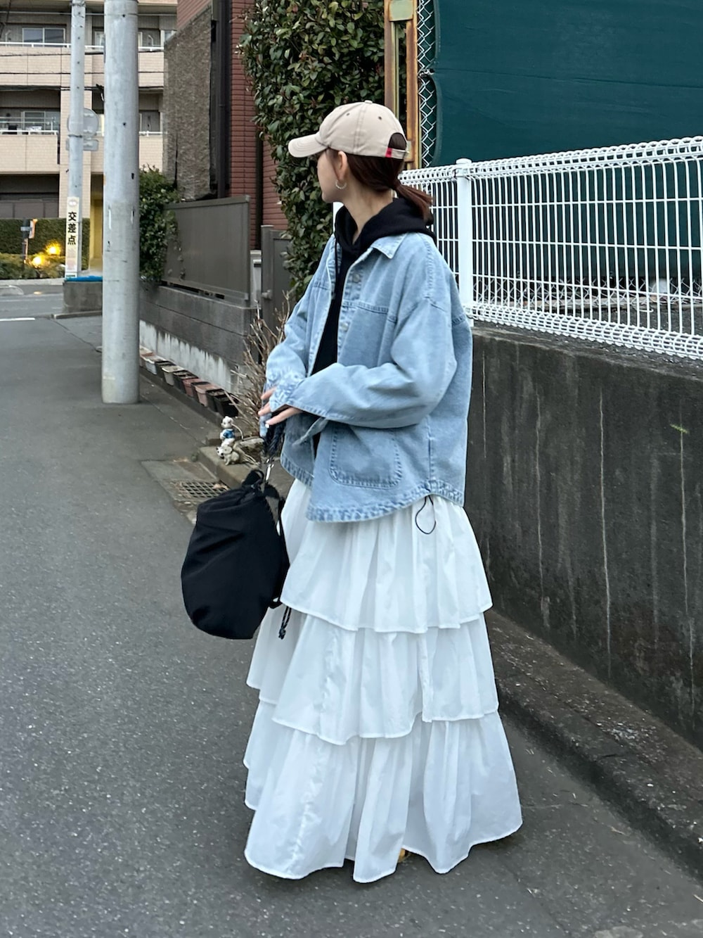 ブルー系のデニムジャケット、ブラック系のスウェット、ホワイト系のスカートを着用したレディースの春コーディネートの3枚目の写真