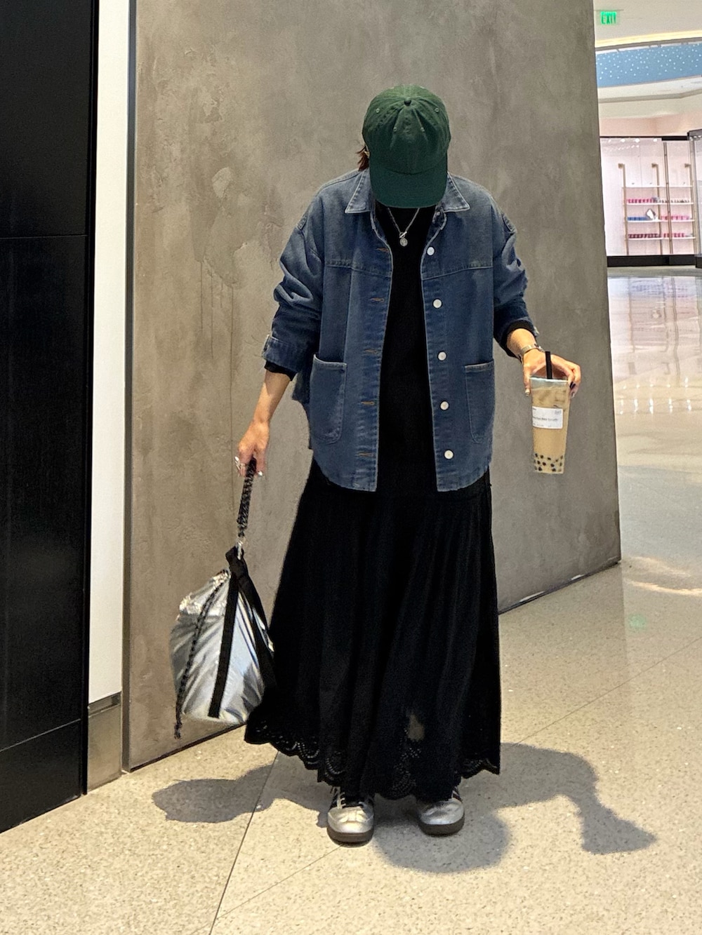 ブルー系のデニムジャケット、ブラック系のTシャツ/カットソー、ブラック系のスカートを着用したレディースの春コーディネートの2枚目の写真