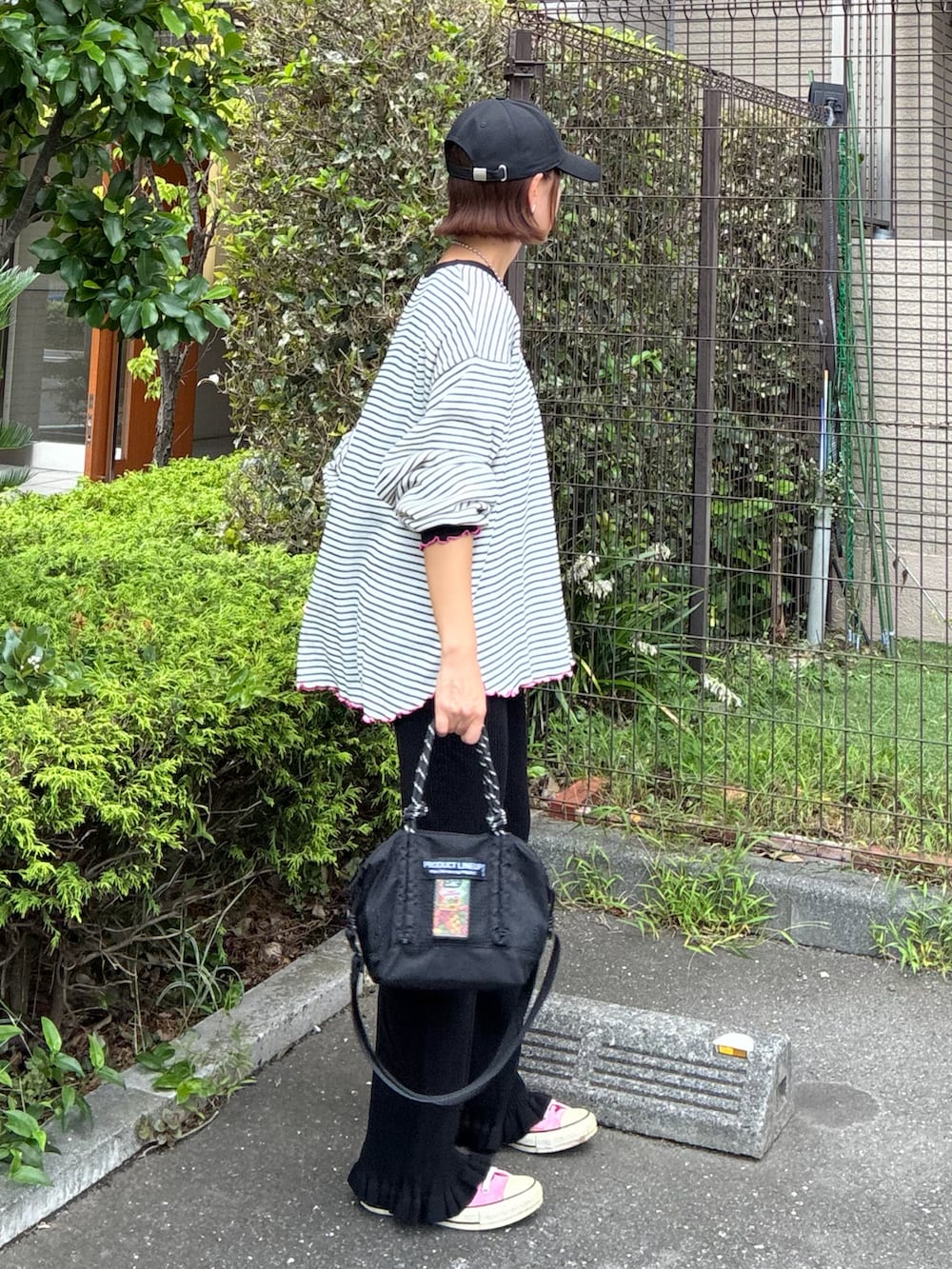 ホワイト系のTシャツ/カットソー、ブラック系のその他パンツ、ブラック系のトートバッグを着用したレディースの秋コーディネートの4枚目の写真