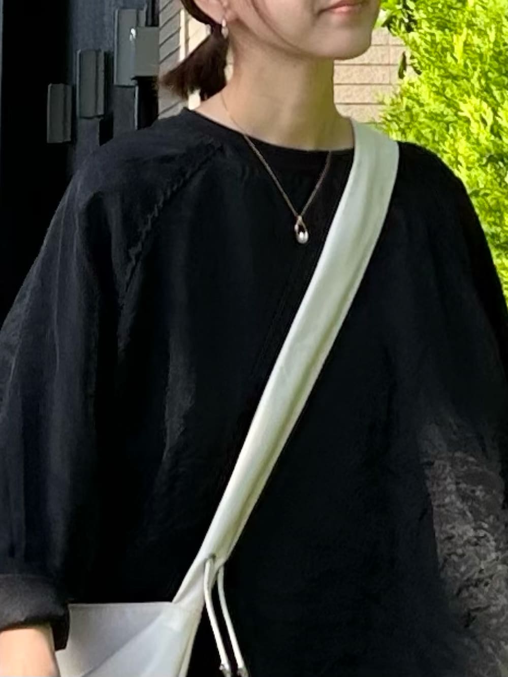 ブラック系のTシャツ/カットソー、ブラック系のその他パンツ、ホワイト系のショルダーバッグを着用したレディースの秋コーディネートの5枚目の写真