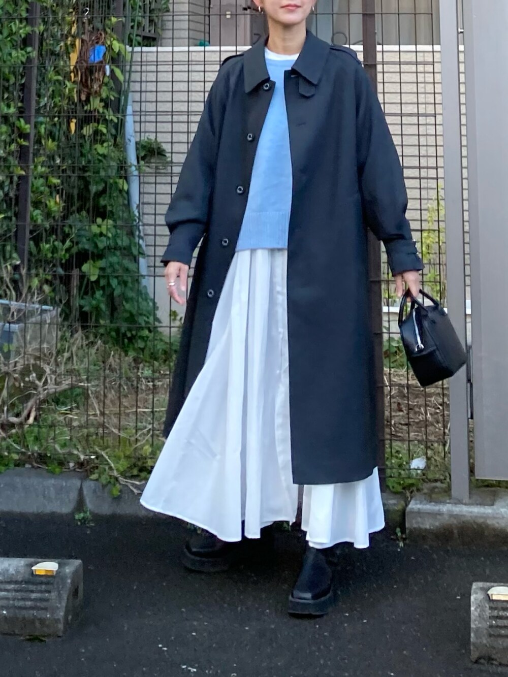 グレー系のその他アウター、ブルー系のニット/セーター、ホワイト系のシャツワンピースを着用したレディースの冬コーディネートの3枚目の写真