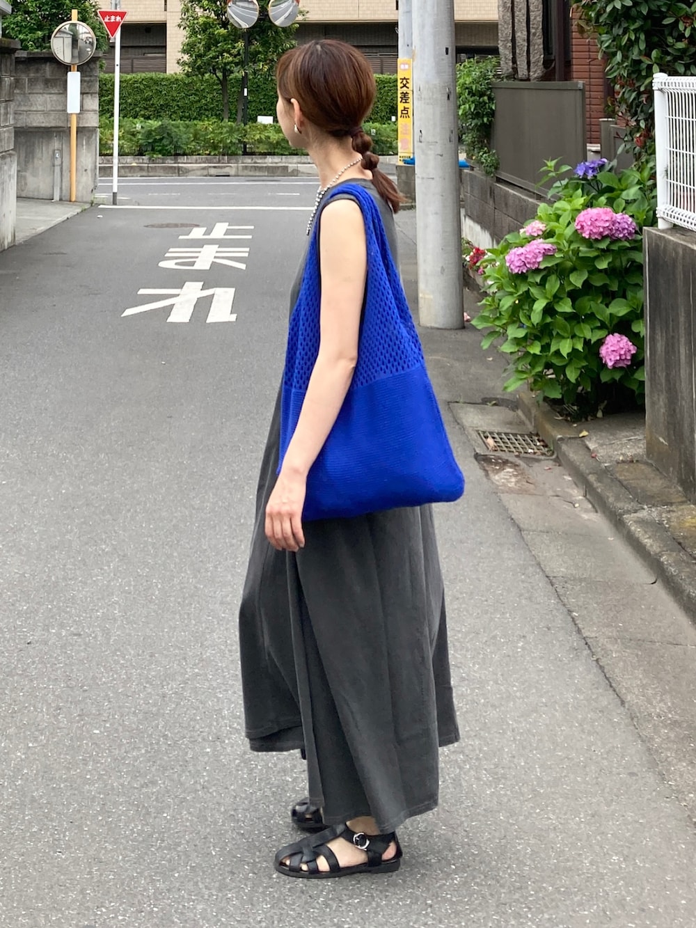 グレー系のワンピース、ブルー系のショルダーバッグ、ブラック系のサンダルを着用したレディースの夏コーディネートの4枚目の写真