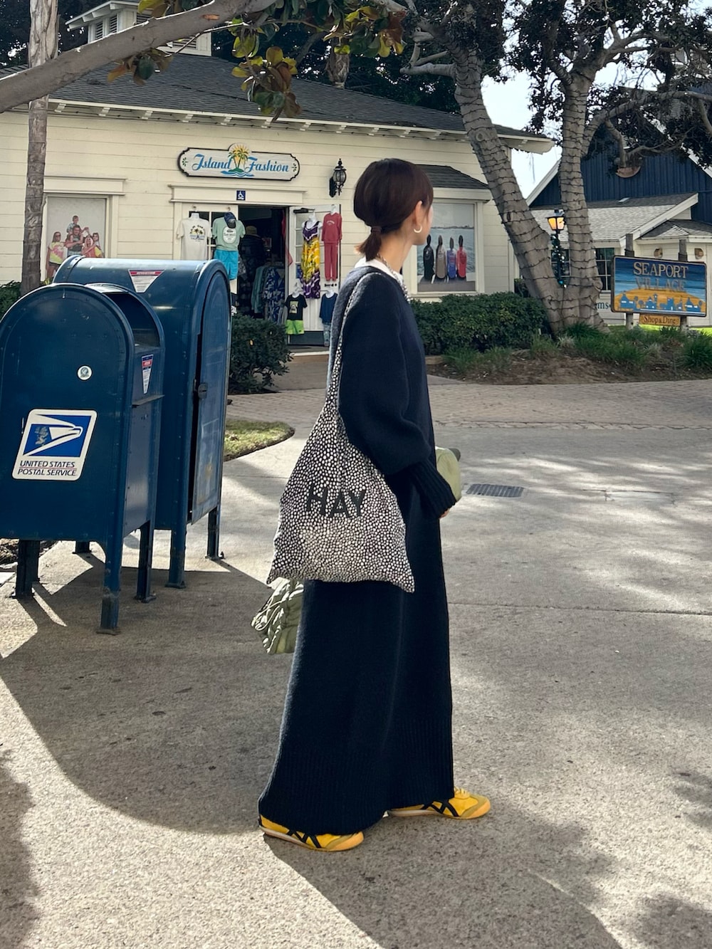 ブラック系のワンピース、グリーン系のノーカラージャケット、ブラック系のトートバッグを着用したレディースの冬コーディネートの3枚目の写真