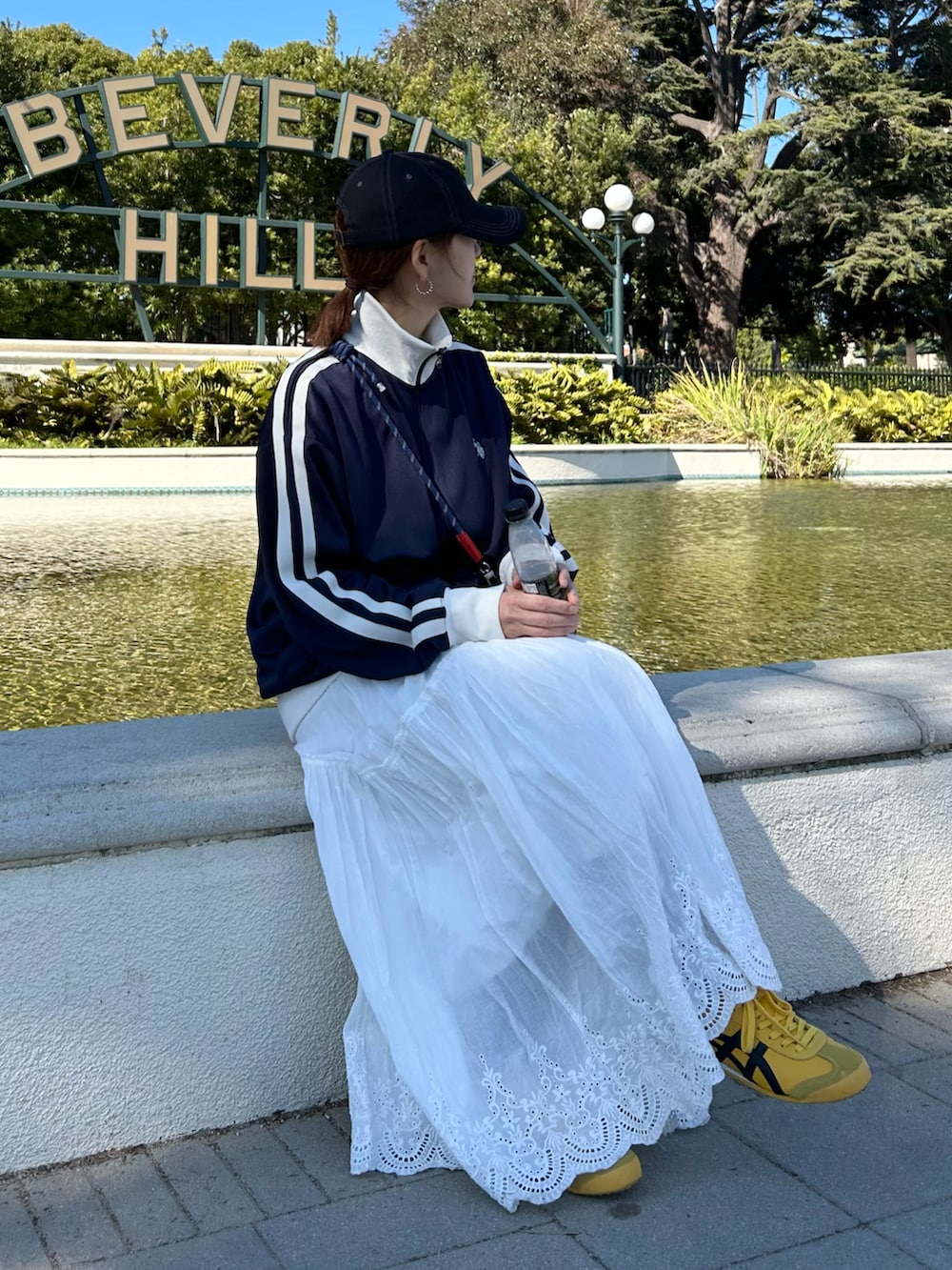 ブルー系のジャージ、ホワイト系のスカート、グレー系のショルダーバッグを着用したレディースの冬コーディネートの5枚目の写真