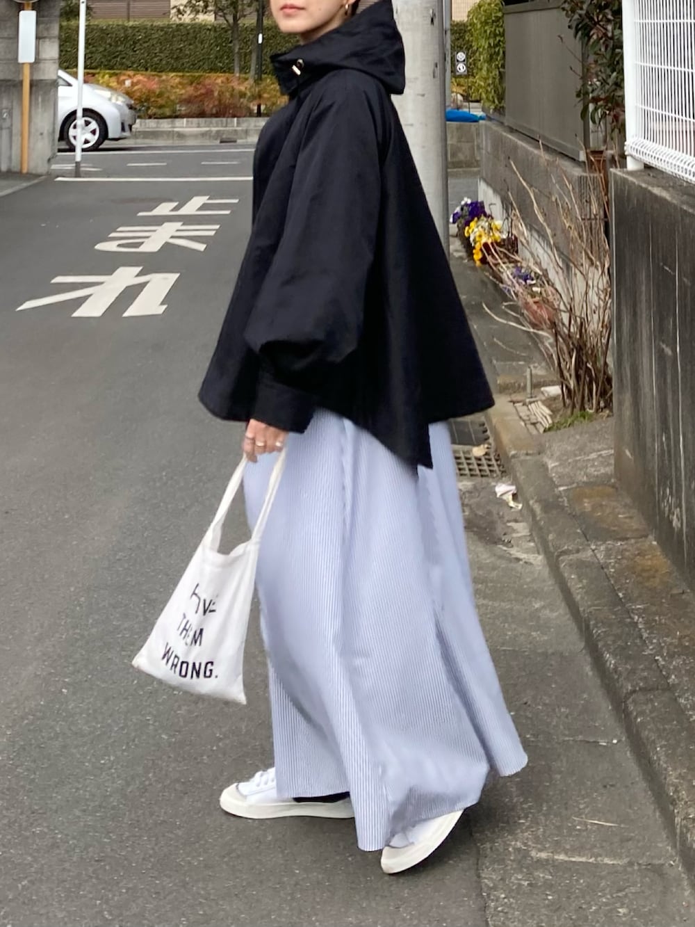 ブラック系のマウンテンパーカー、ブラック系のワンピース、ホワイト系のトートバッグを着用したレディースの冬コーディネートの4枚目の写真