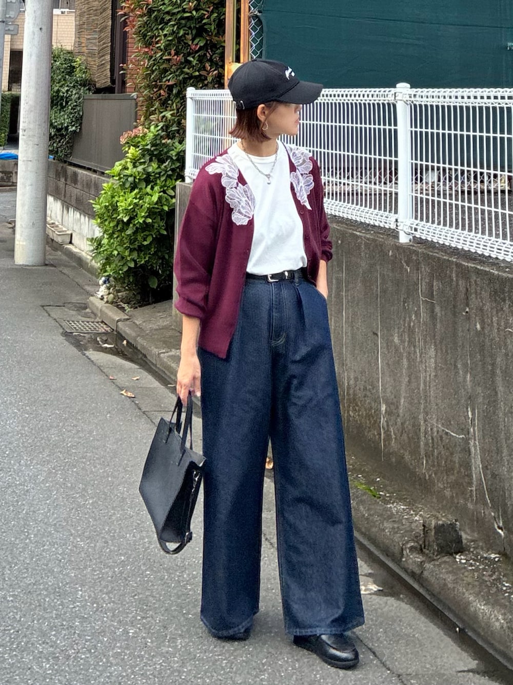 レッド系のカーディガン/ボレロ、ブラック系のTシャツ/カットソー、ブルー系のデニムパンツを着用したレディースの秋コーディネートの2枚目の写真
