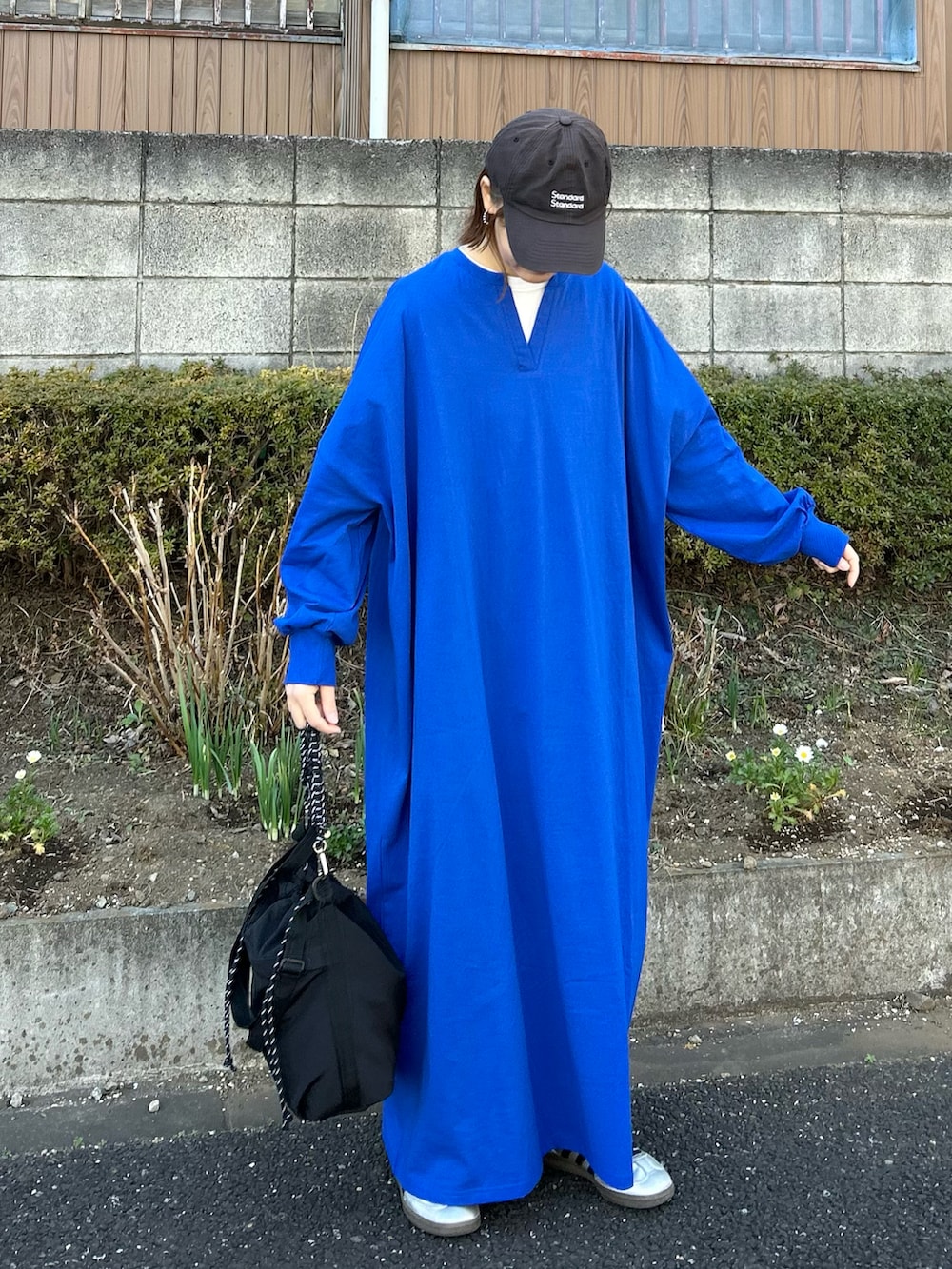 ブラック系のトートバッグ、ブルー系のワンピース、シルバー系のスニーカーを着用したレディースの冬コーディネートの5枚目の写真