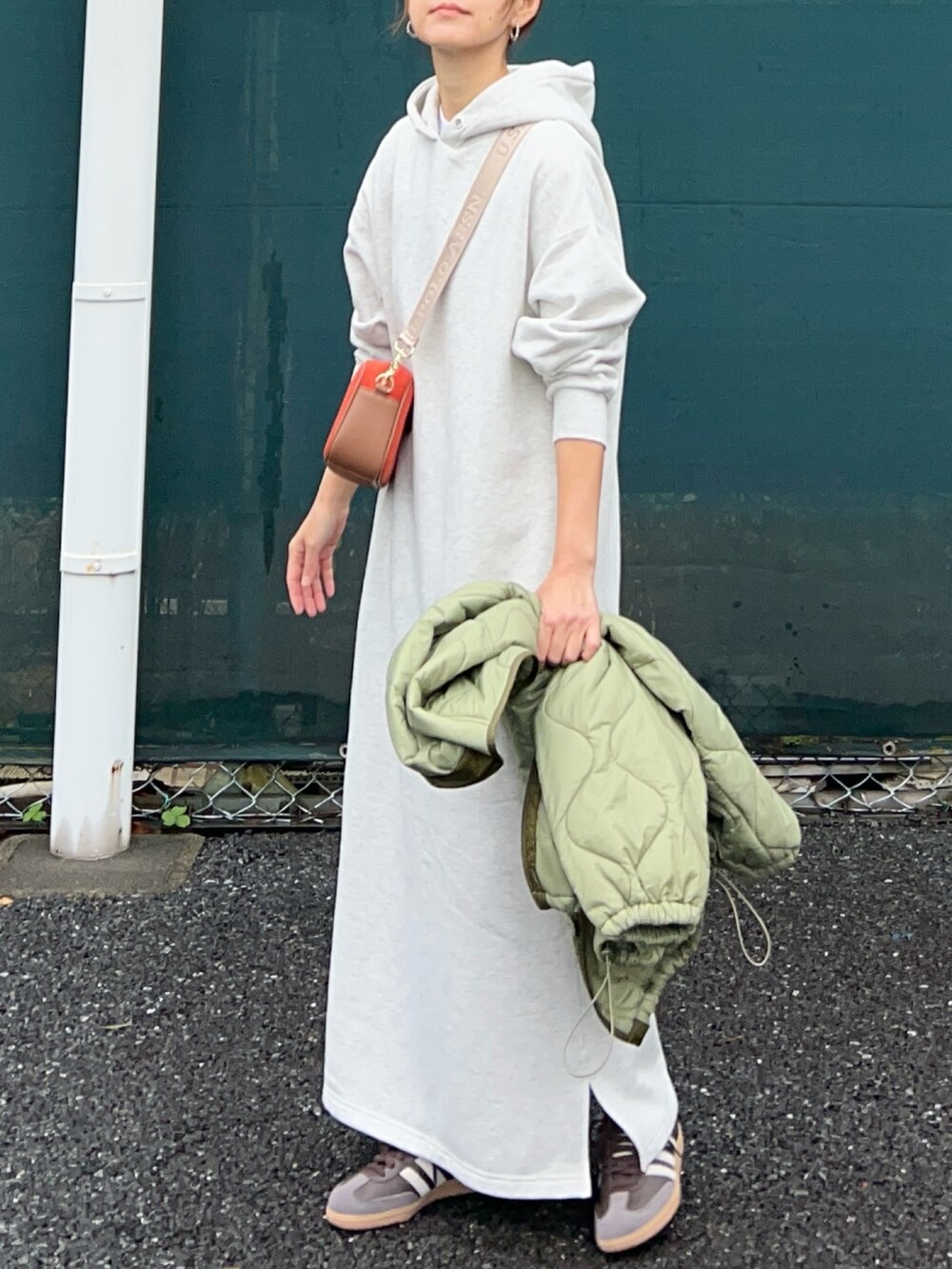 オレンジ系のショルダーバッグ、グレー系のワンピース、グリーン系のノーカラージャケットを着用したレディースの秋コーディネートの3枚目の写真