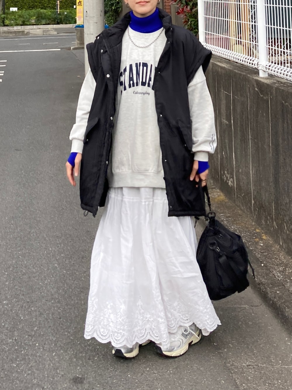 ブラック系のダウンジャケット/コート、ホワイト系のスウェット、ホワイト系のスカートを着用したレディースの秋コーディネートの5枚目の写真