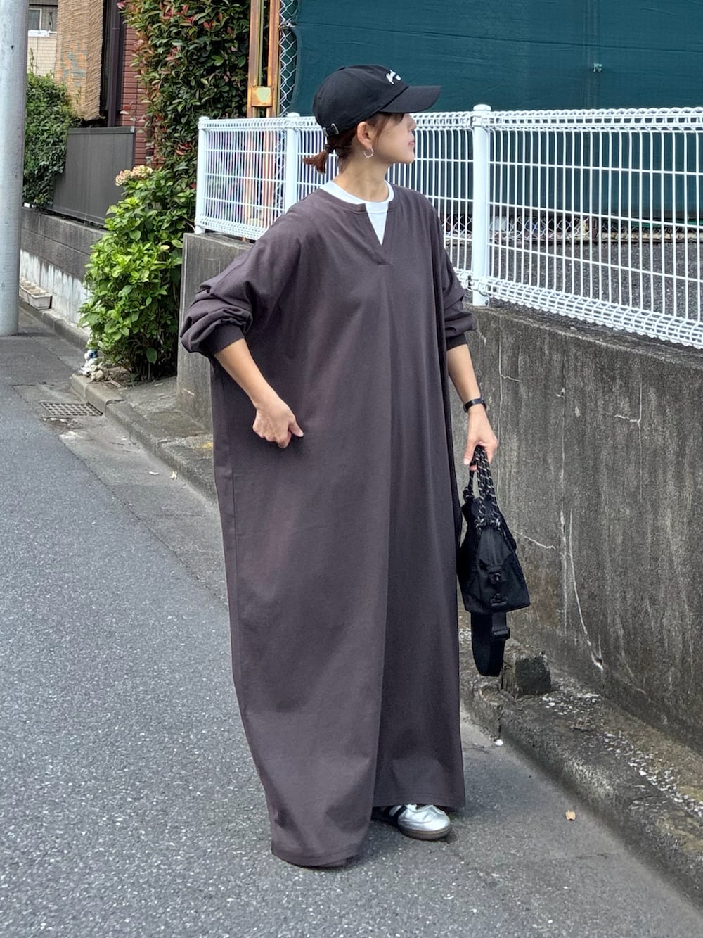 ブラウン系のワンピース、ブラック系のトートバッグ、ブラック系のキャップを着用したレディースの秋コーディネートの4枚目の写真