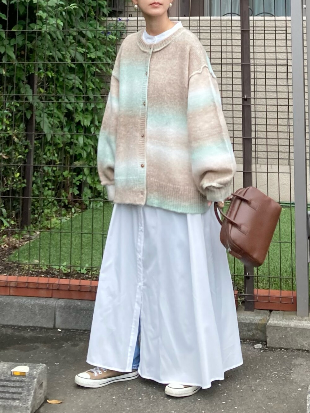 グリーン系のカーディガン/ボレロ、ホワイト系のワンピース、ブラウン系のボストンバッグを着用したレディースの秋コーディネートの3枚目の写真