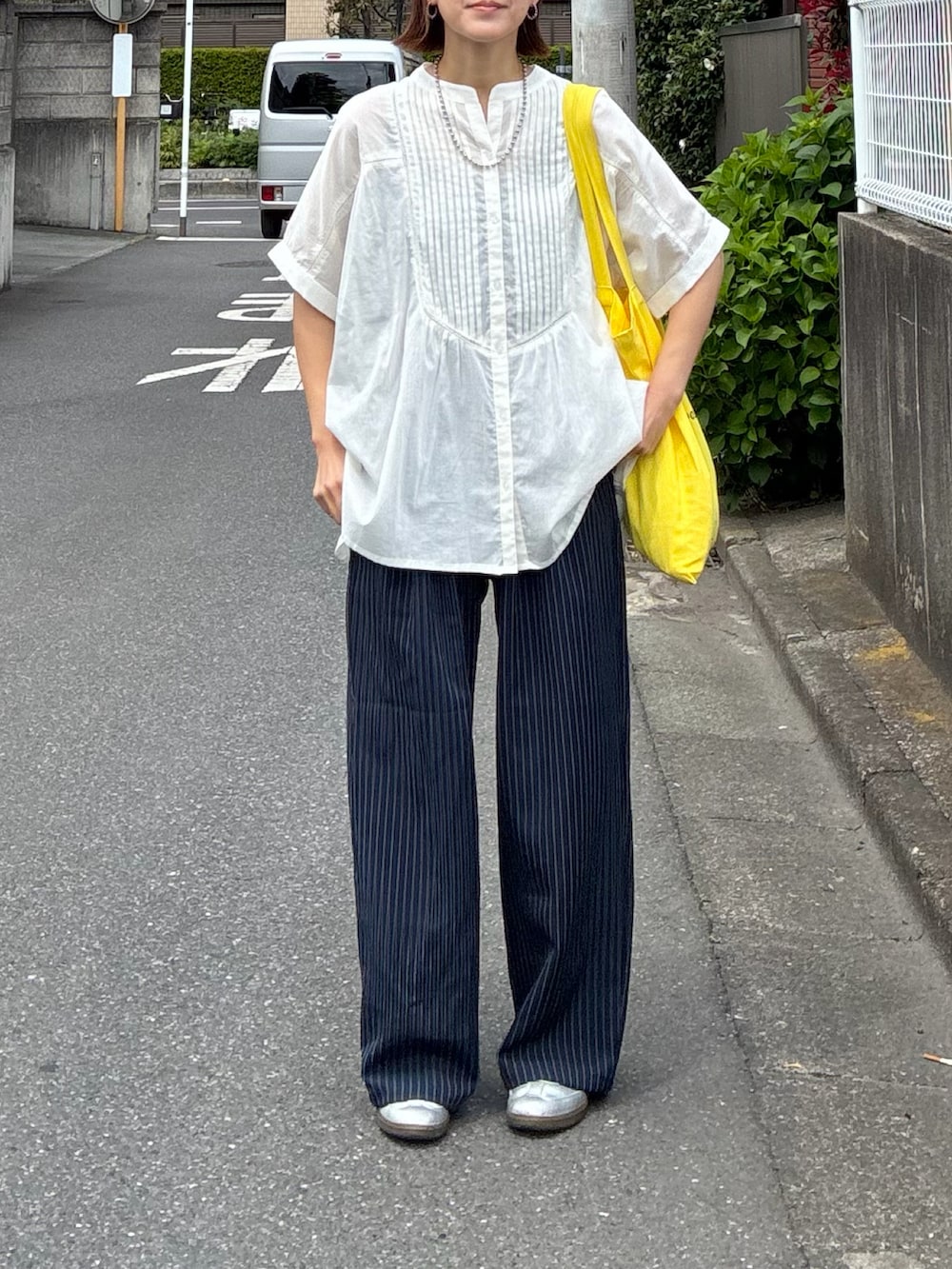 ホワイト系のシャツ/ブラウス、ブルー系のスラックス、イエロー系のトートバッグを着用したレディースの春コーディネートの2枚目の写真