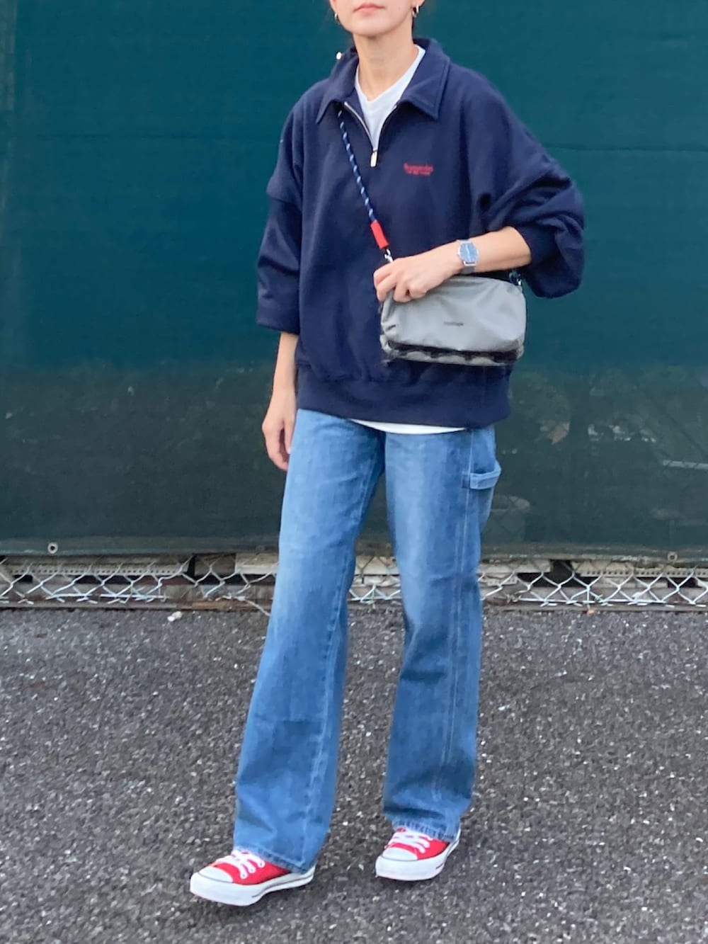 ブルー系のスウェット、ブルー系のデニムパンツ、グレー系のショルダーバッグを着用したレディースの秋コーディネートの3枚目の写真