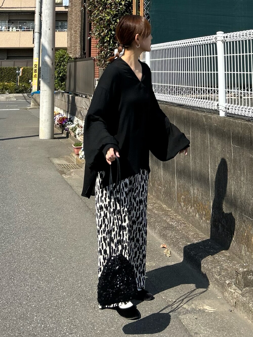 ブラック系のシャツ/ブラウス、ブラック系のショルダーバッグ、ホワイト系のその他パンツを着用したレディースの春コーディネートの2枚目の写真