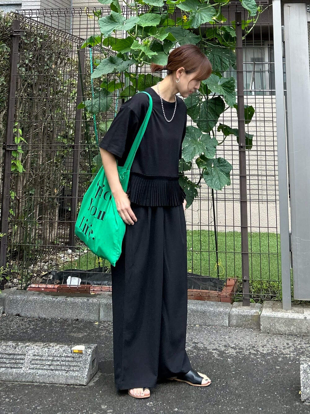 ブラック系のTシャツ/カットソー、ブラック系のその他パンツ、グリーン系のトートバッグを着用したレディースの夏コーディネートの4枚目の写真