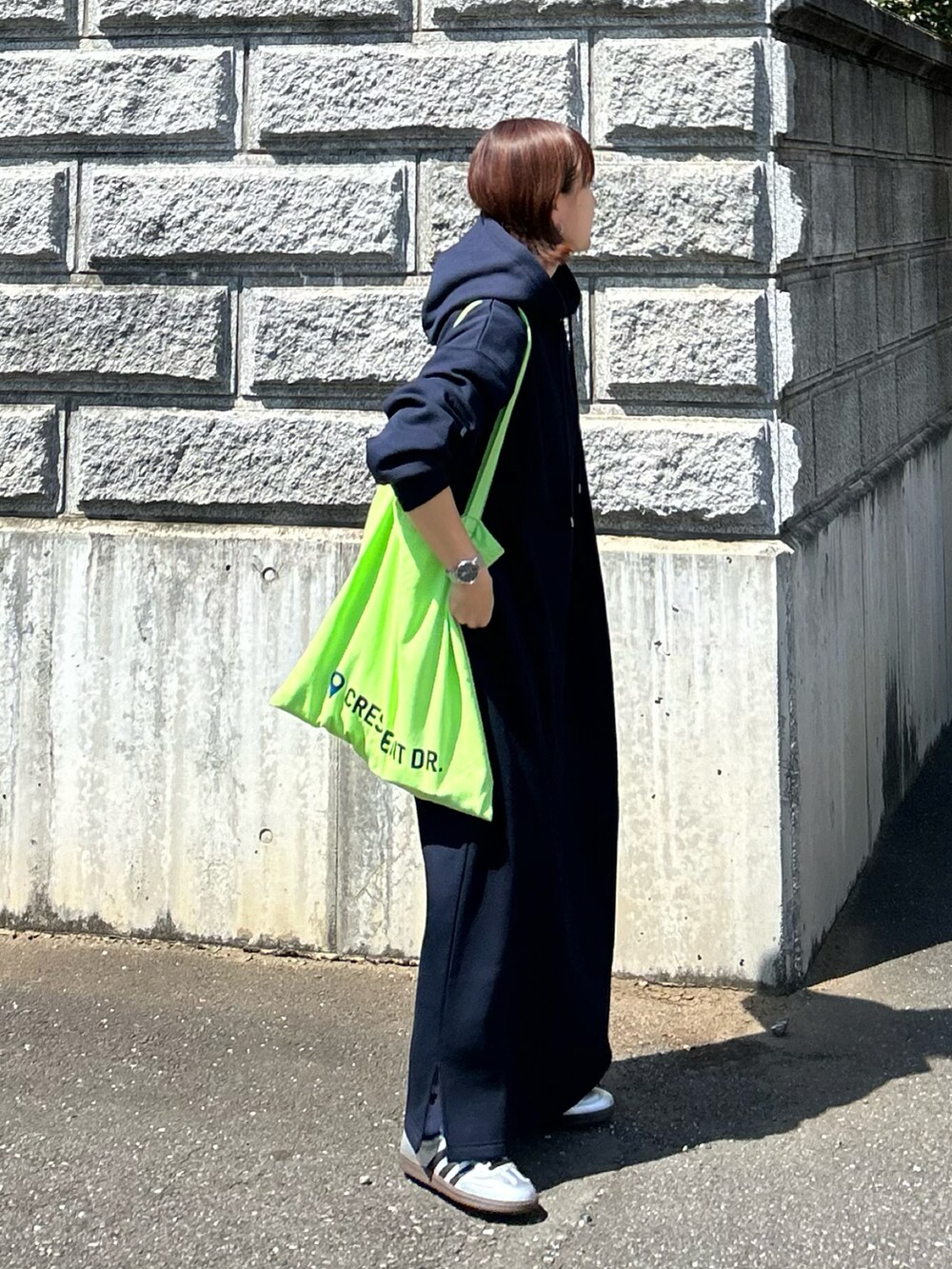 ブルー系のワンピース、グリーン系のトートバッグ、シルバー系のスニーカーを着用したレディースの秋コーディネートの4枚目の写真