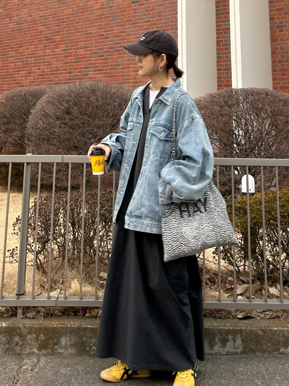 ブルー系のデニムジャケット、グレー系のワンピース、イエロー系のスニーカーを着用したレディースの冬コーディネートの2枚目の写真