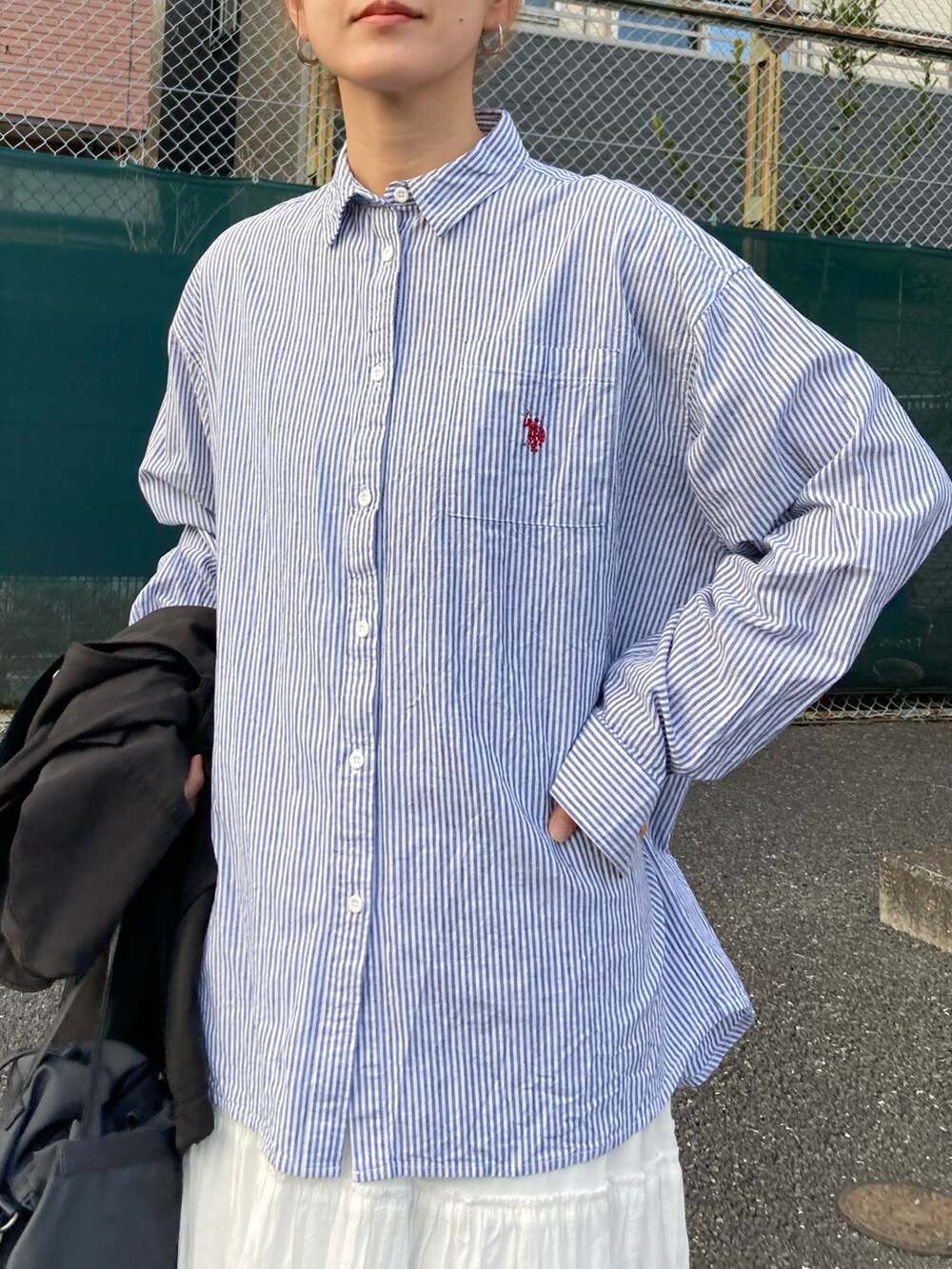 ブラック系のベスト、ブルー系のシャツ/ブラウス、ホワイト系のスカートを着用したレディースの冬コーディネートの4枚目の写真