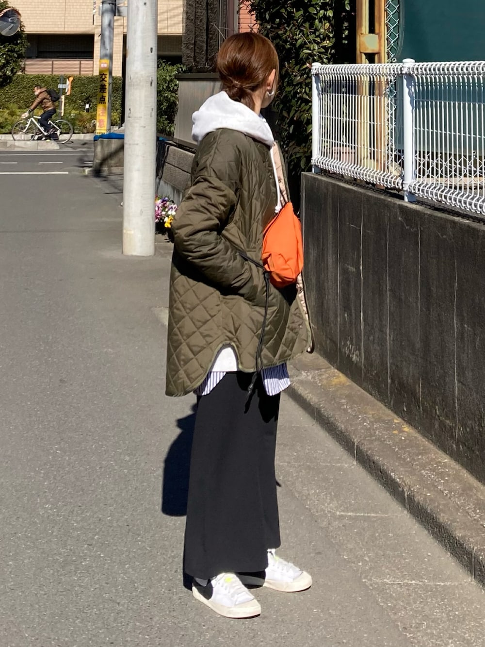 グリーン系のブルゾン、グレー系のパーカー、ブラック系のスカートを着用したレディースの冬コーディネートの3枚目の写真