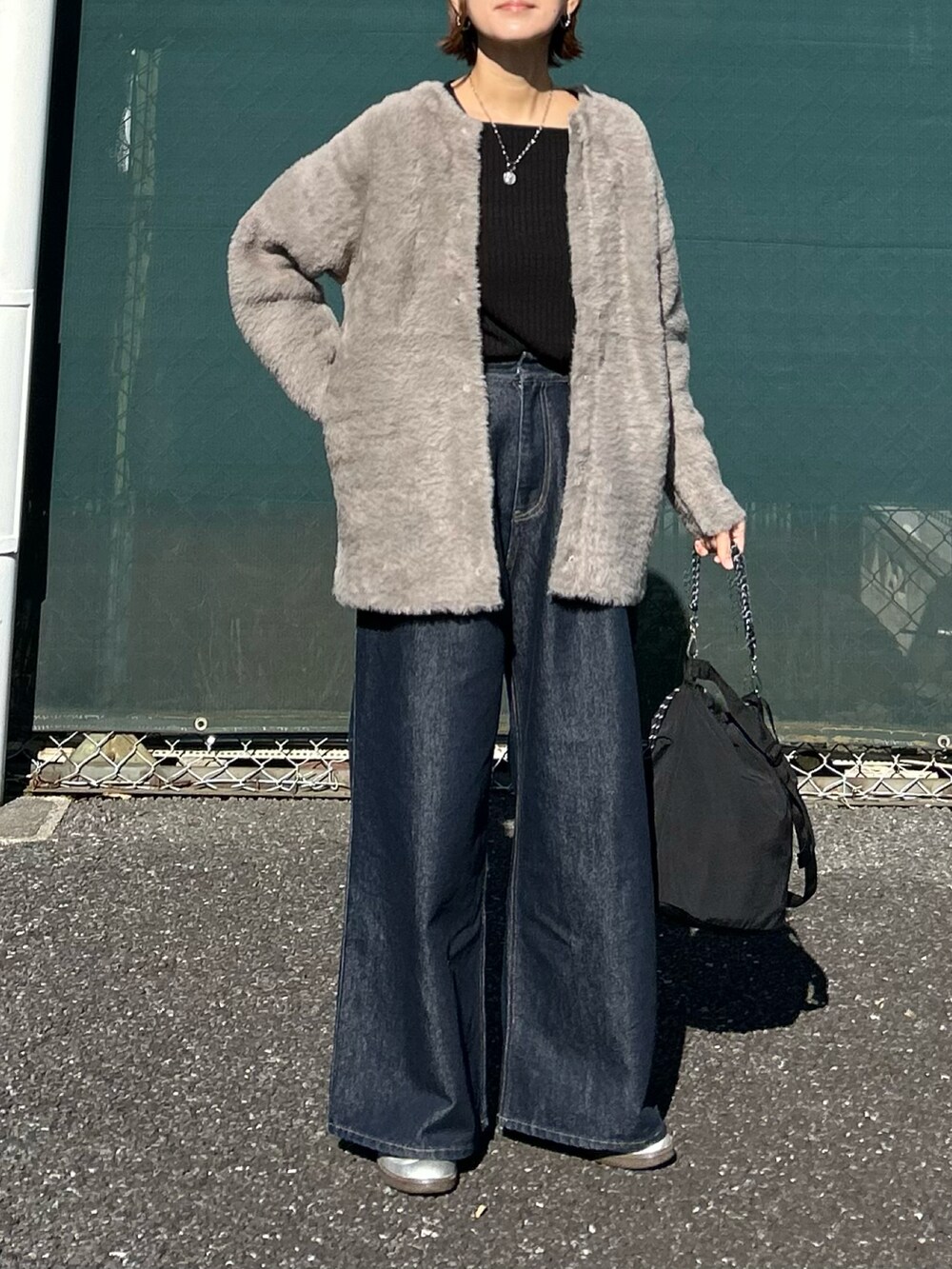 グレー系のカーディガン/ボレロ、ブラック系のTシャツ/カットソー、ブルー系のデニムパンツを着用したレディースの冬コーディネートの2枚目の写真