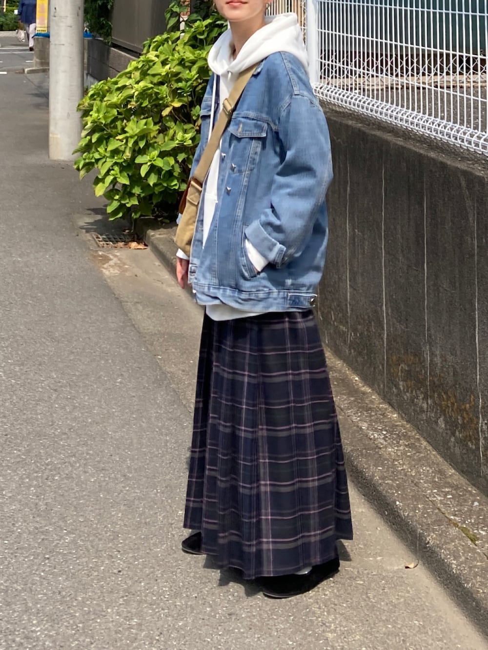ホワイト系のパーカー、ブルー系のデニムジャケット、ブルー系のスカートを着用したレディースの秋コーディネートの5枚目の写真