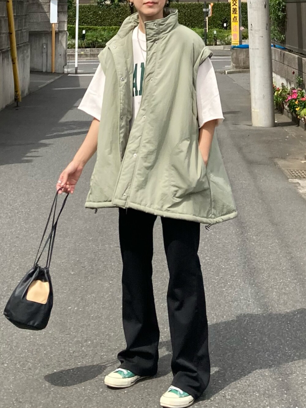 グリーン系のダウンジャケット/コート、ブラック系のその他パンツ、ホワイト系のスウェットを着用したレディースの秋コーディネートの4枚目の写真