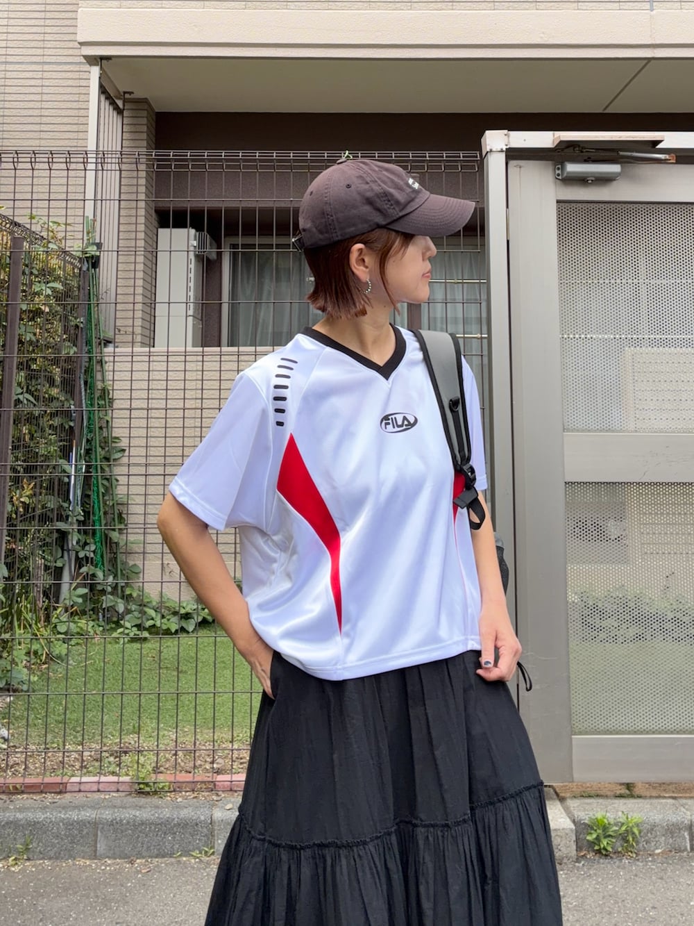 グレー系のバックパック/リュック、ホワイト系のトップス、ブラック系のスカートを着用したレディースの春コーディネートの2枚目の写真