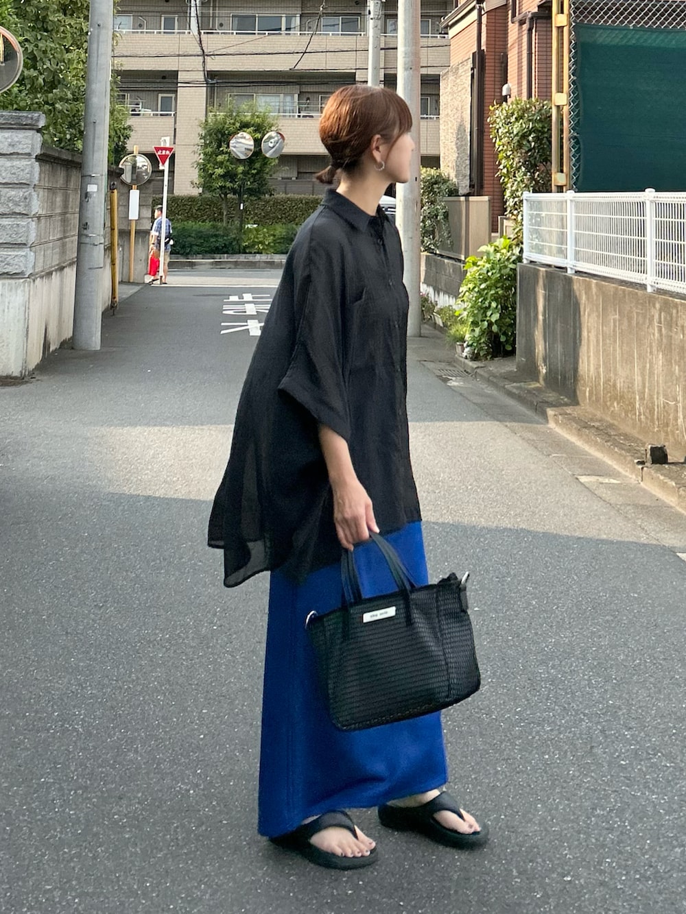 ブラック系のシャツ/ブラウス、ブルー系のスカート、ブラック系のバッグを着用したレディースの夏コーディネートの4枚目の写真