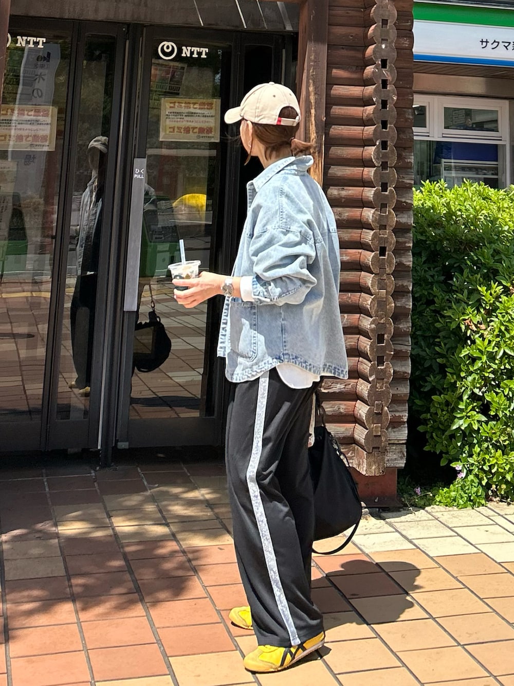 ブルー系のデニムジャケット、ホワイト系のシャツ/ブラウス、ブラック系のスラックスを着用したレディースの春コーディネートの3枚目の写真