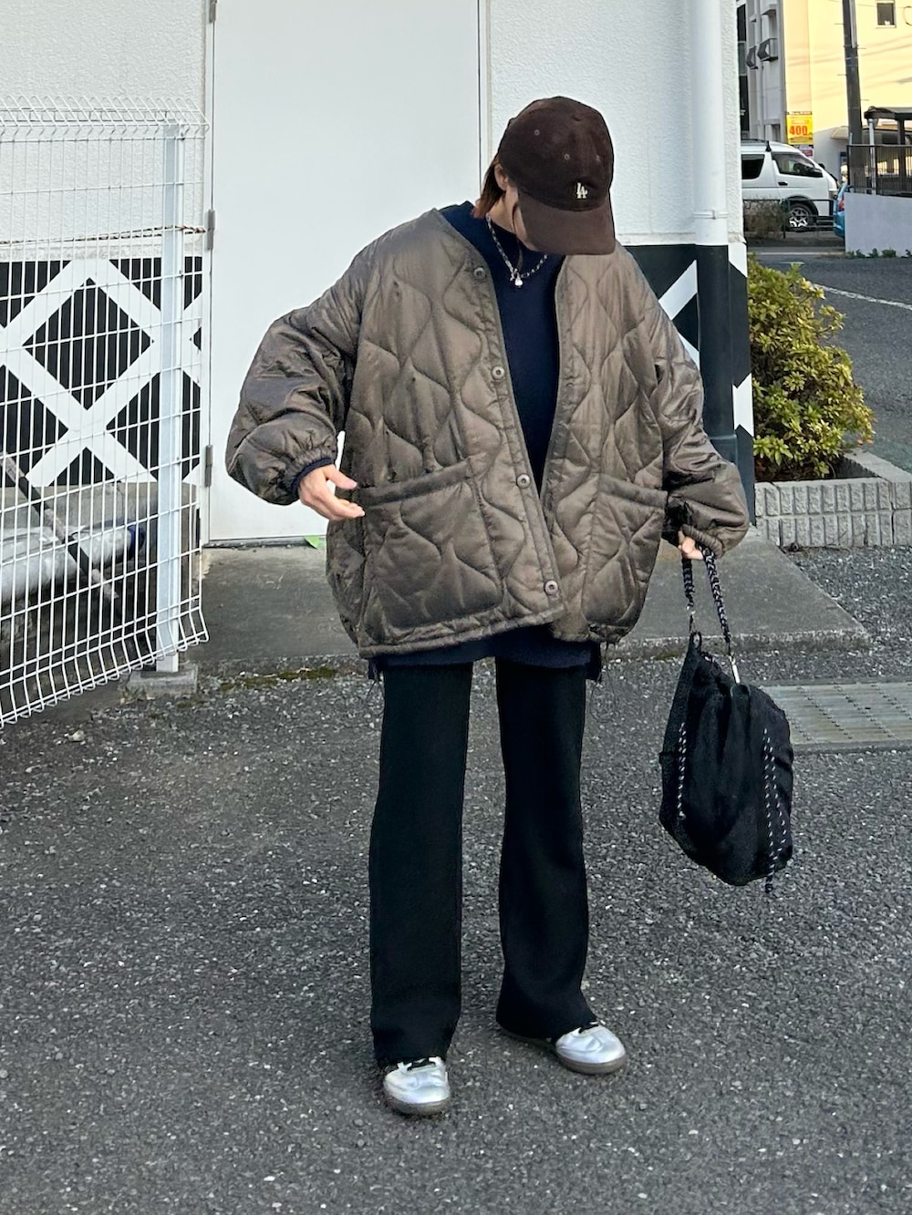 ブラウン系のブルゾン、ブルー系のスウェット、ブラック系のトートバッグを着用したレディースの冬コーディネートの3枚目の写真