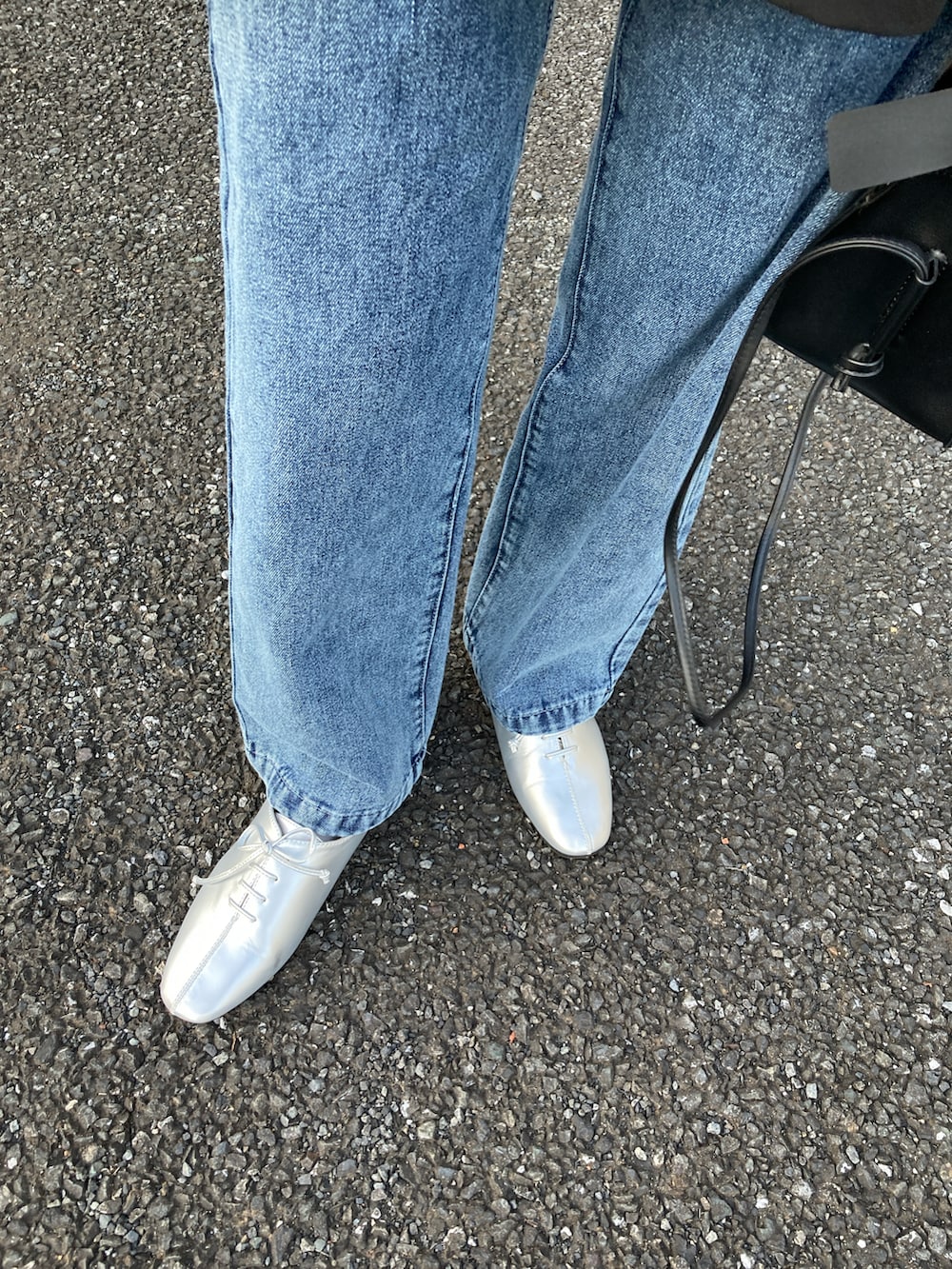 ブラック系のシャツ/ブラウス、ブルー系のデニムパンツ、シルバー系のドレスシューズを着用したレディースの冬コーディネートの4枚目の写真