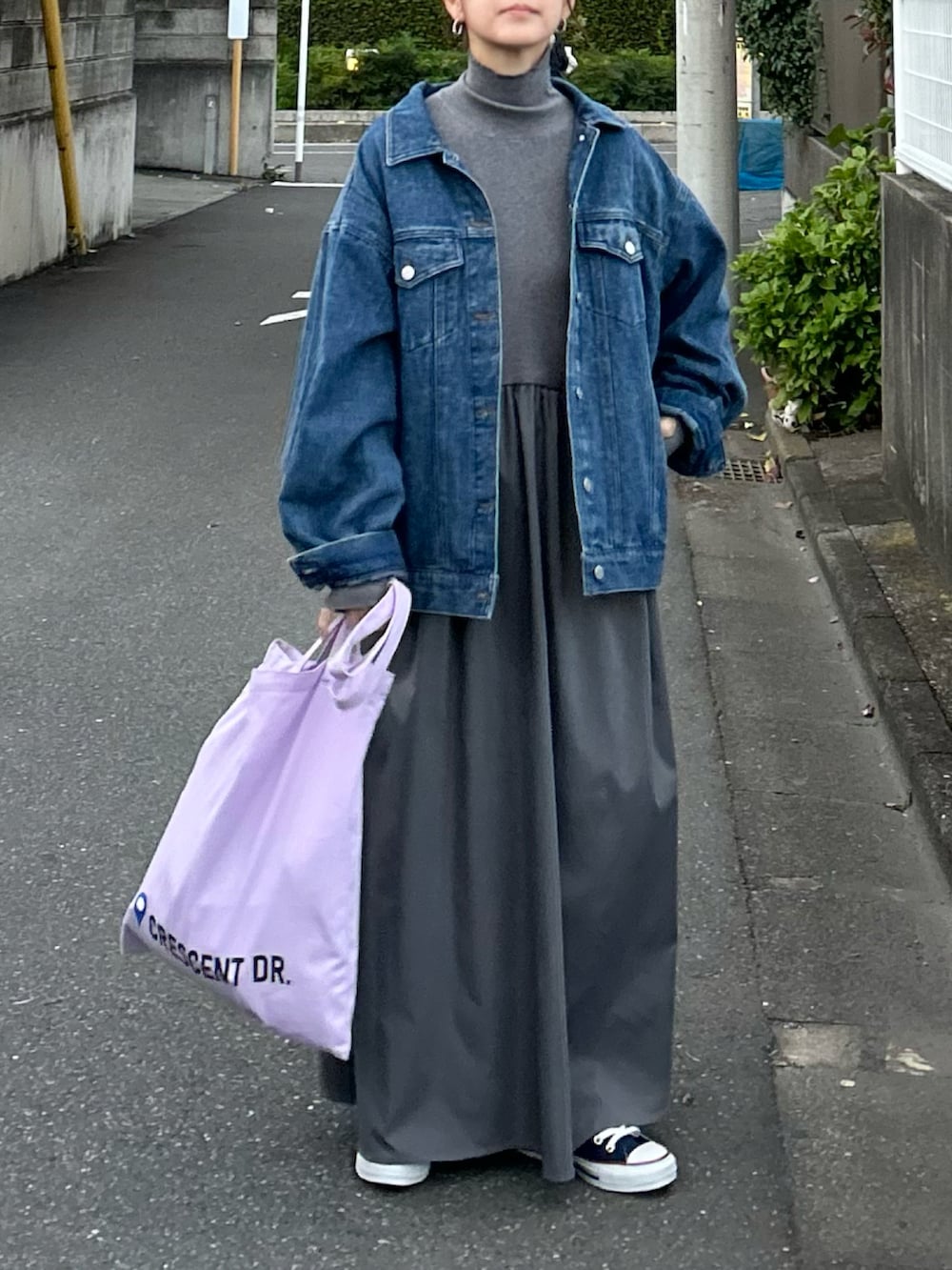 グレー系のワンピース、パープル系のトートバッグ、ブルー系のデニムジャケットを着用したレディースの冬コーディネートの5枚目の写真