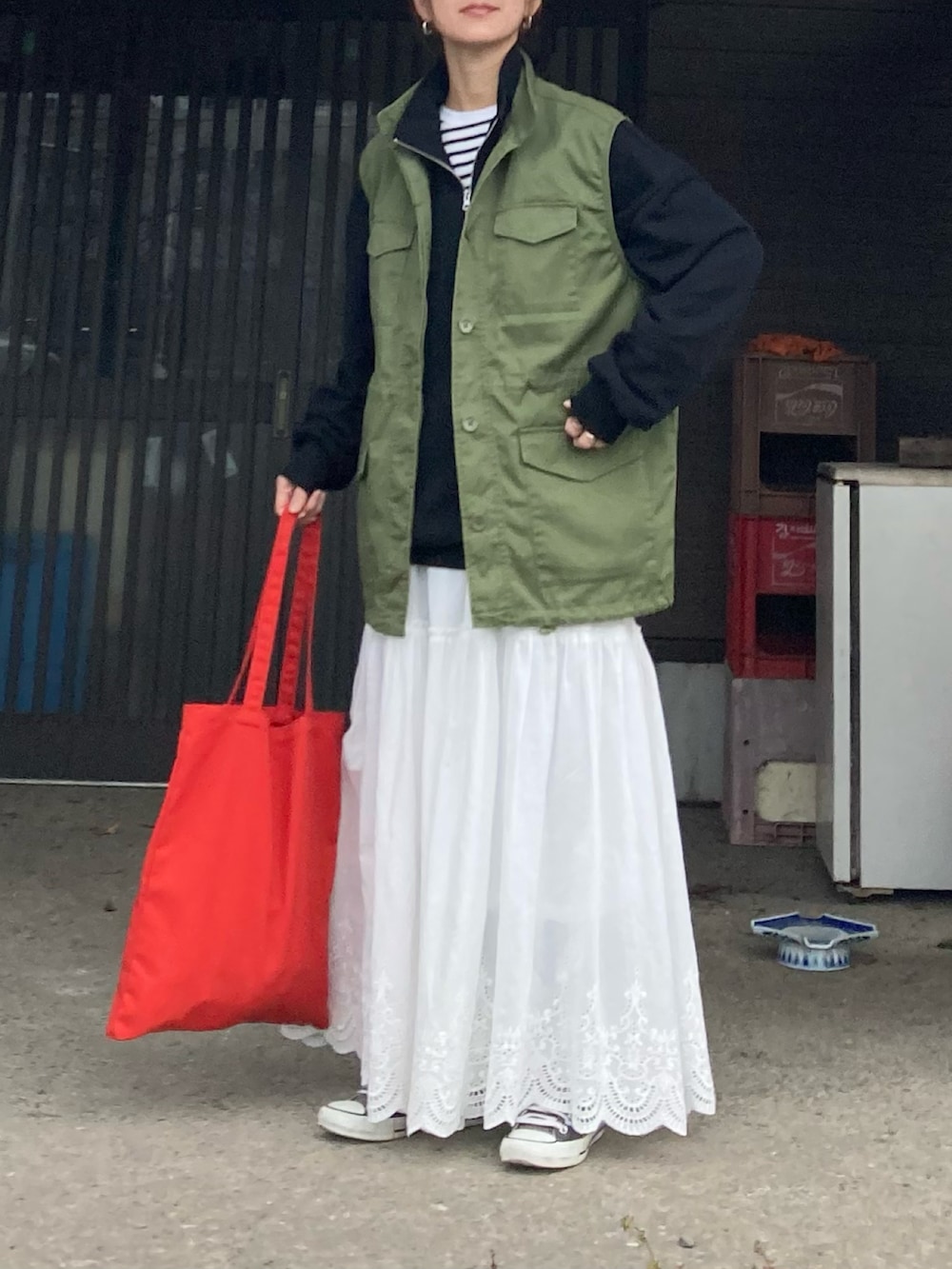 ブラック系のスウェット、グリーン系のベスト、ホワイト系のスカートを着用したレディースの冬コーディネートの3枚目の写真