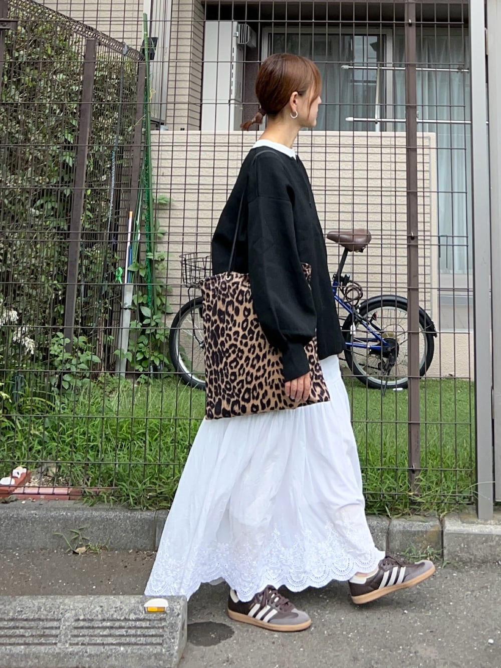 ブラック系のニット/セーター、ホワイト系のTシャツ/カットソー、ホワイト系のスカートを着用したレディースの秋コーディネートの2枚目の写真