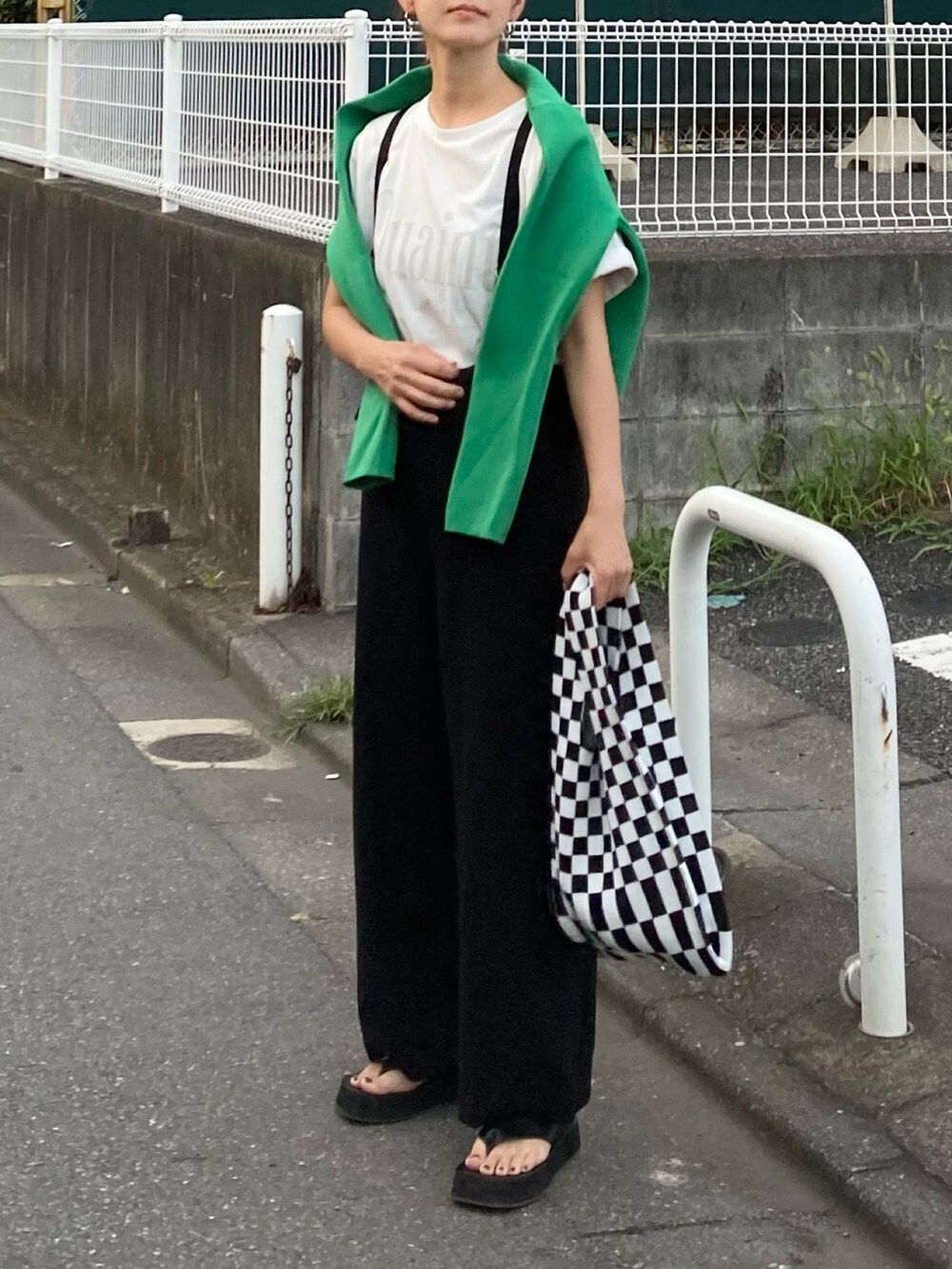 ホワイト系のTシャツ/カットソー、ブラック系のサロペット/オーバーオール、ブラック系のサンダルを着用したレディースの夏コーディネートの3枚目の写真