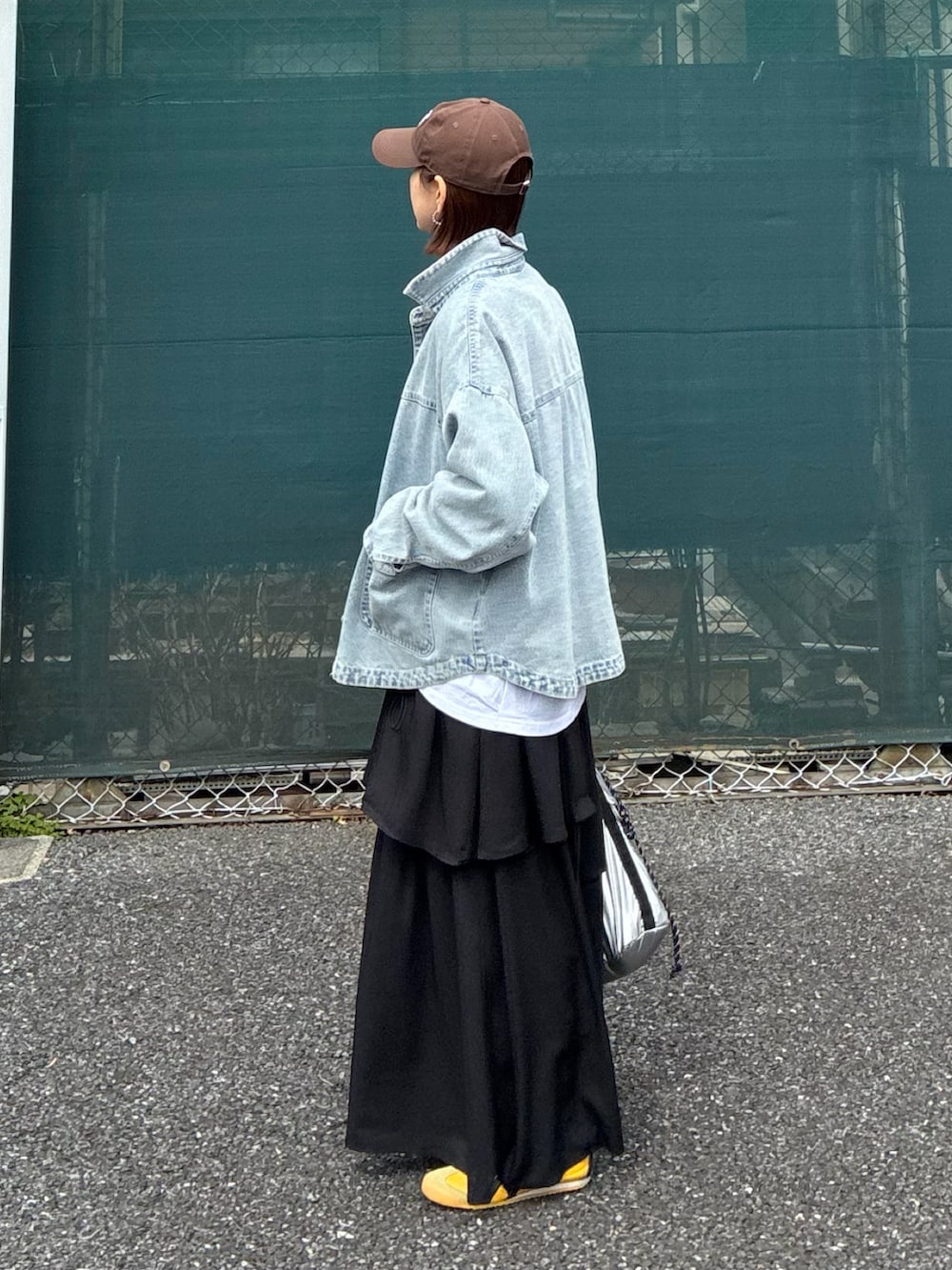 ホワイト系のTシャツ/カットソー、ブルー系のデニムジャケット、ブラック系のスカートを着用したレディースの春コーディネートの5枚目の写真