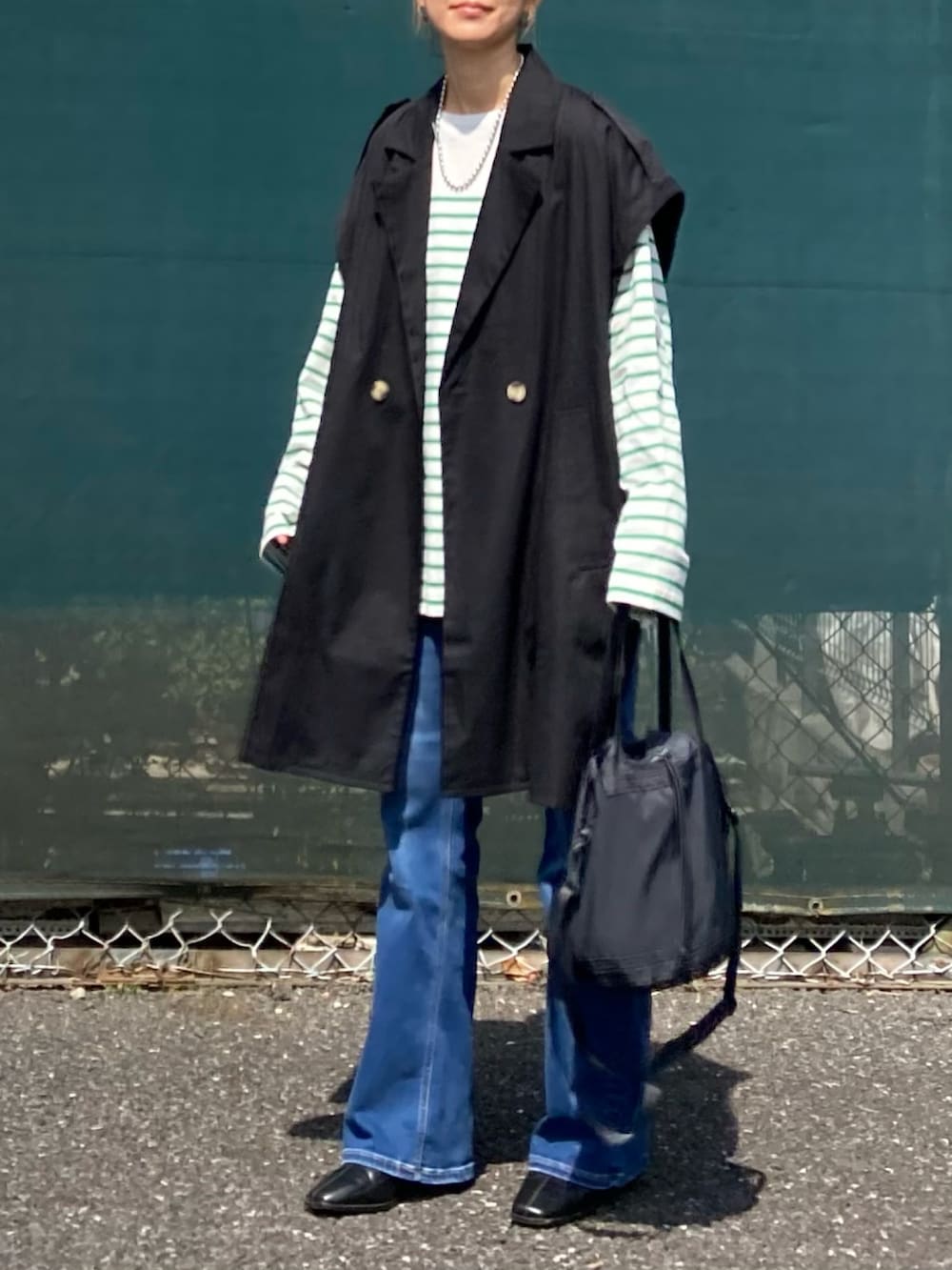 グリーン系のTシャツ/カットソー、ブラック系のその他アウター、ブルー系のデニムパンツを着用したレディースの春コーディネートの4枚目の写真