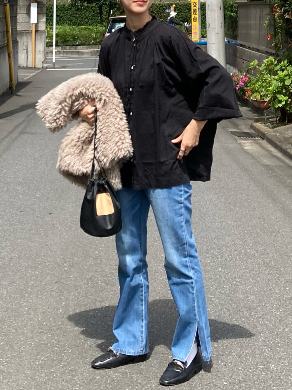 ブラック系のシャツ/ブラウス、ブルー系のデニムパンツ、ベージュ系のベストを着用したレディースの秋コーディネートの3枚目の写真