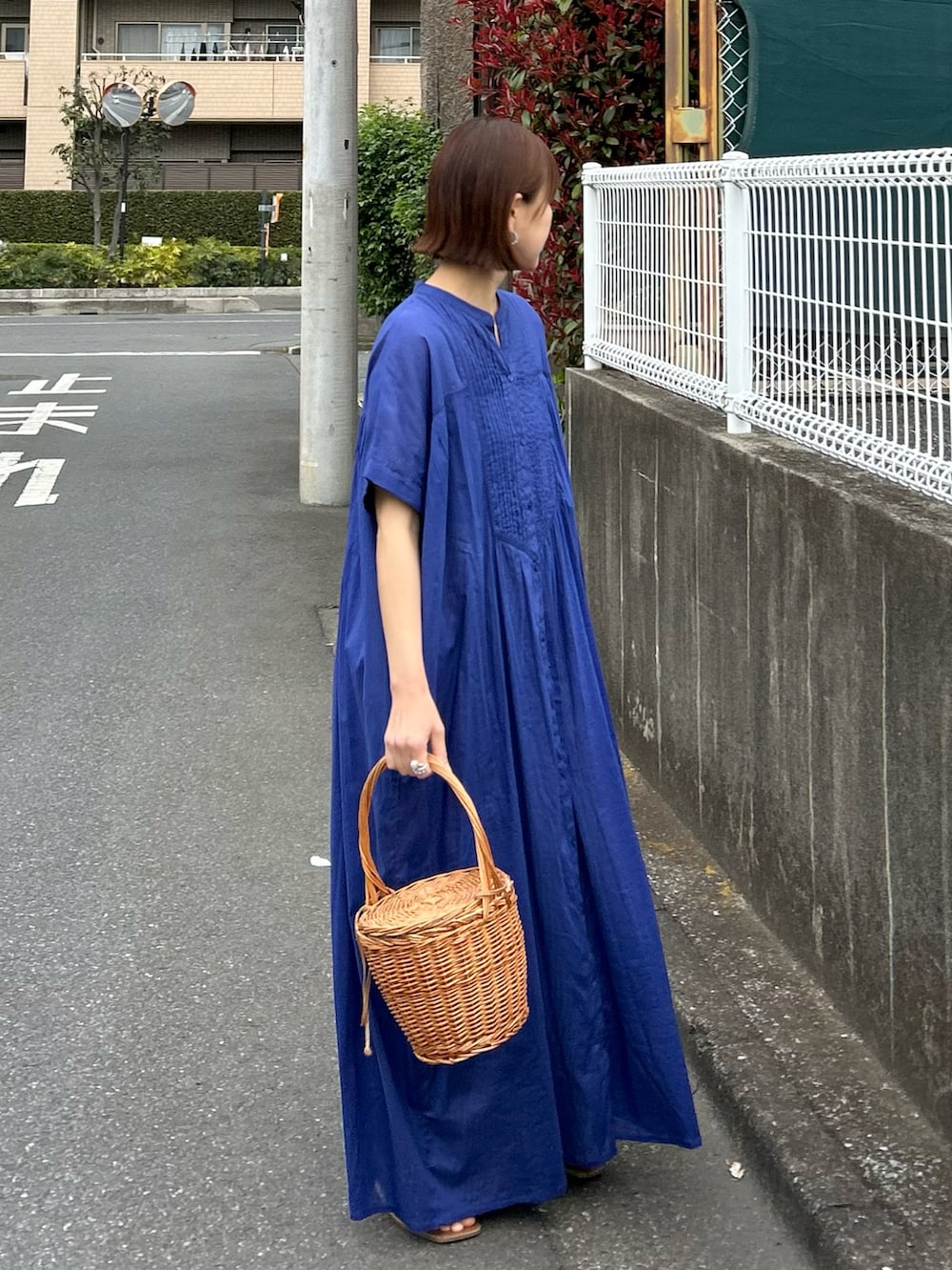 ブルー系のワンピース、ベージュ系のキャップを着用したレディースの春コーディネートの2枚目の写真