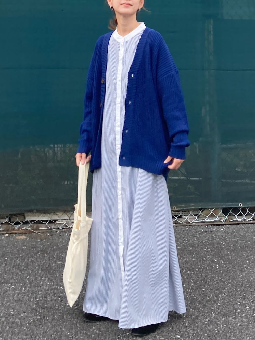 ブルー系のカーディガン/ボレロ、ブラック系のワンピース、ホワイト系のトートバッグを着用したレディースの秋コーディネートの3枚目の写真