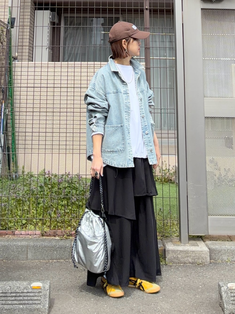 ホワイト系のTシャツ/カットソー、ブルー系のデニムジャケット、ブラック系のスカートを着用したレディースの春コーディネートの2枚目の写真