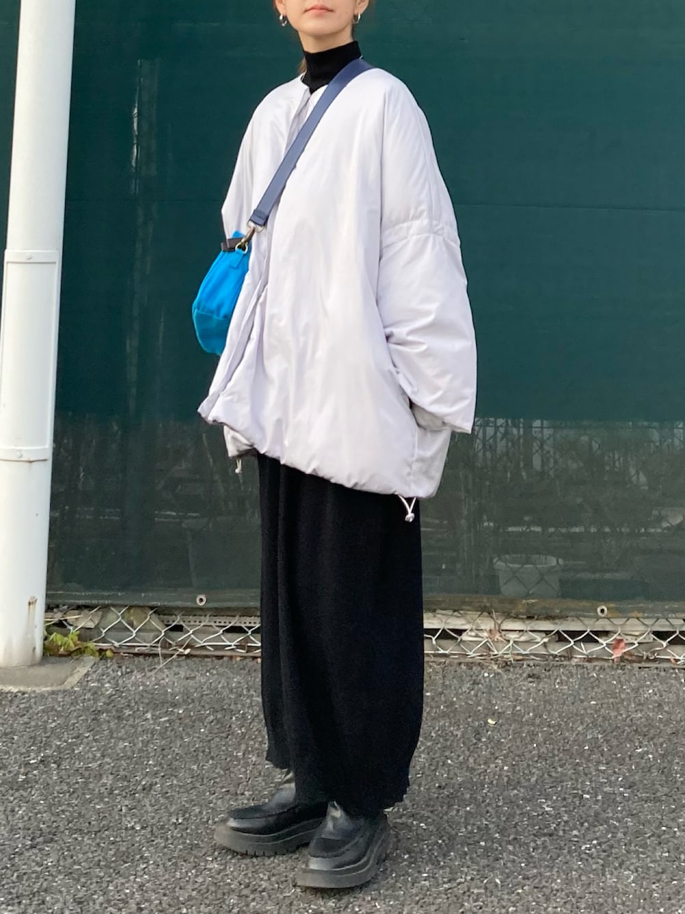 グレー系のその他アウター、ブラック系のワンピース、ブルー系のショルダーバッグを着用したレディースの冬コーディネートの3枚目の写真